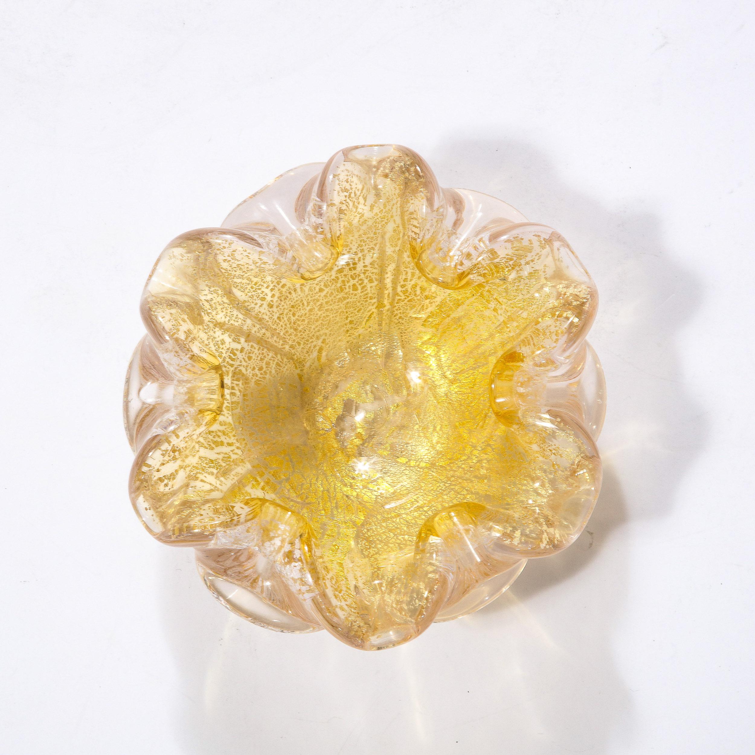 This warm and elegant Mid-Century Modernist Hand-Blown Murano Glass Dish originates from Italy, Circa 1950. Featuring an expansive organic profile reminiscent of a flower in bloom, the piece is hand-blown in stunning transparent glass with 24 Karat