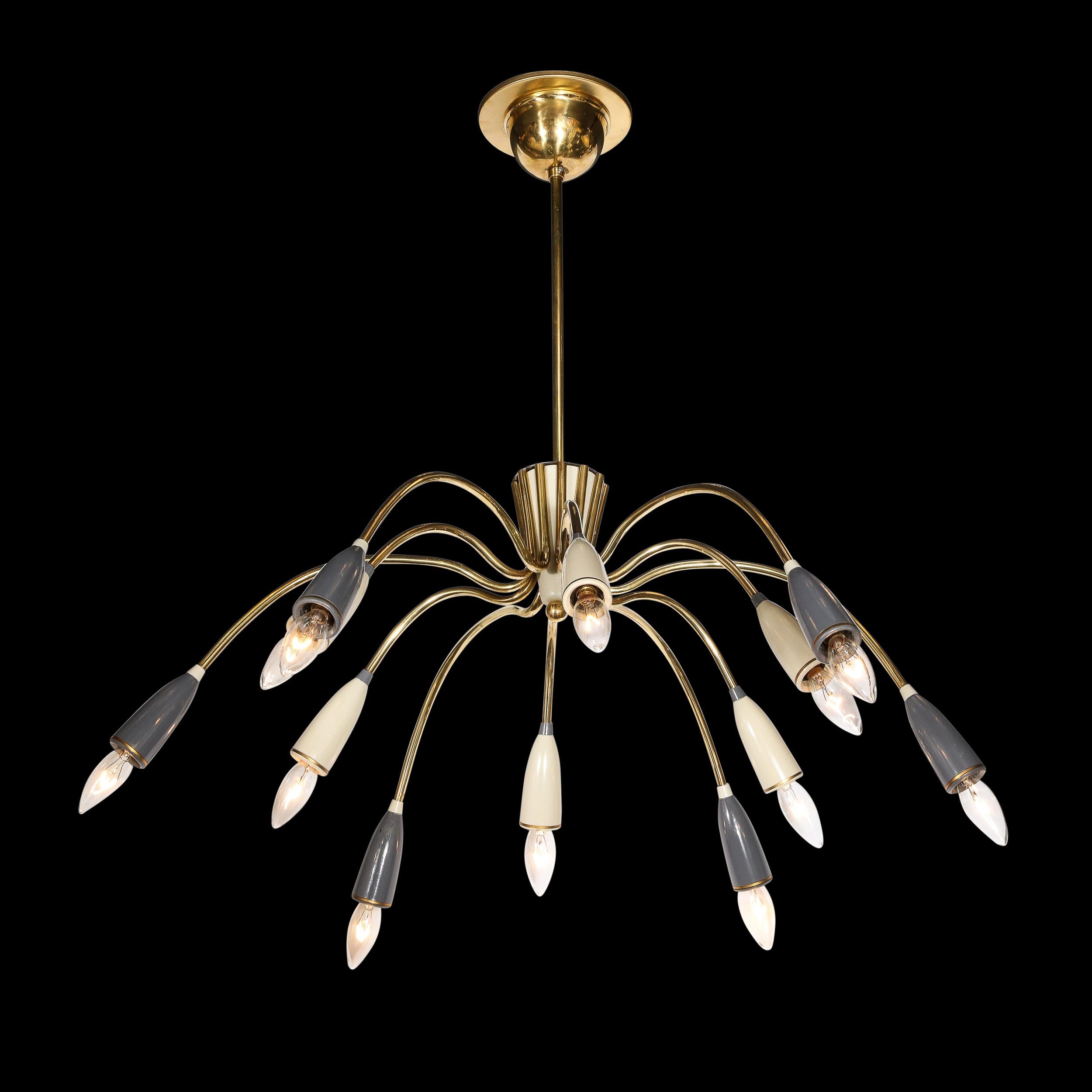 This beautiful and sophisticated Mid-Century Modernist Twelve Arm Brass and Enamel Chandelier is by the company Stilnovo and originates from Italy, Circa 1950. Featuring an expansive profile with twelve arms at alternating levels of extension from a