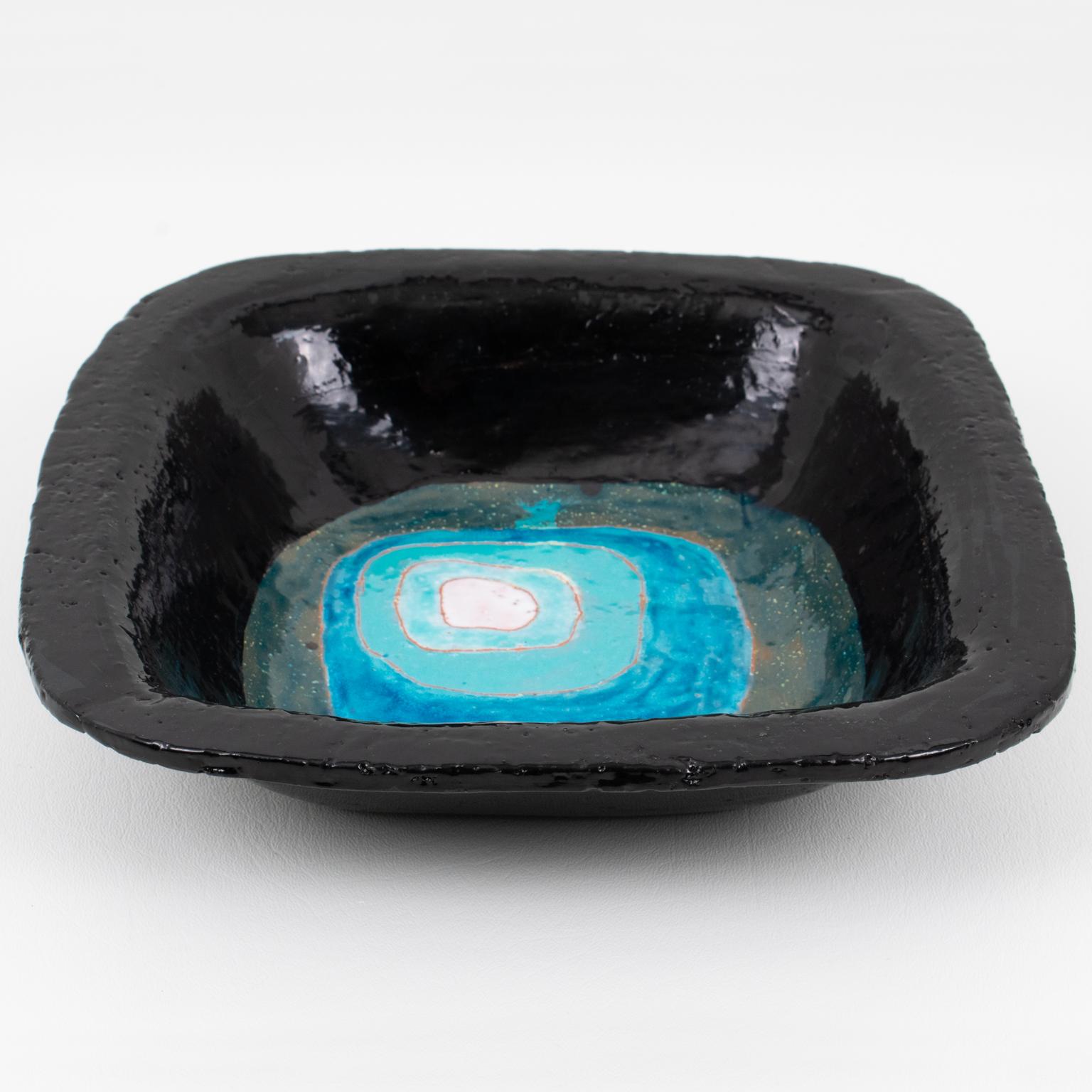 This lovely Mid-Century modernist ceramic cigar ashtray, desk tidy, vide poche, or catchall, was crafted in Vallauris, France, in the 1960s. The elevated faux-square form has a glazed texture with black as the primary color and a kaleidoscopic