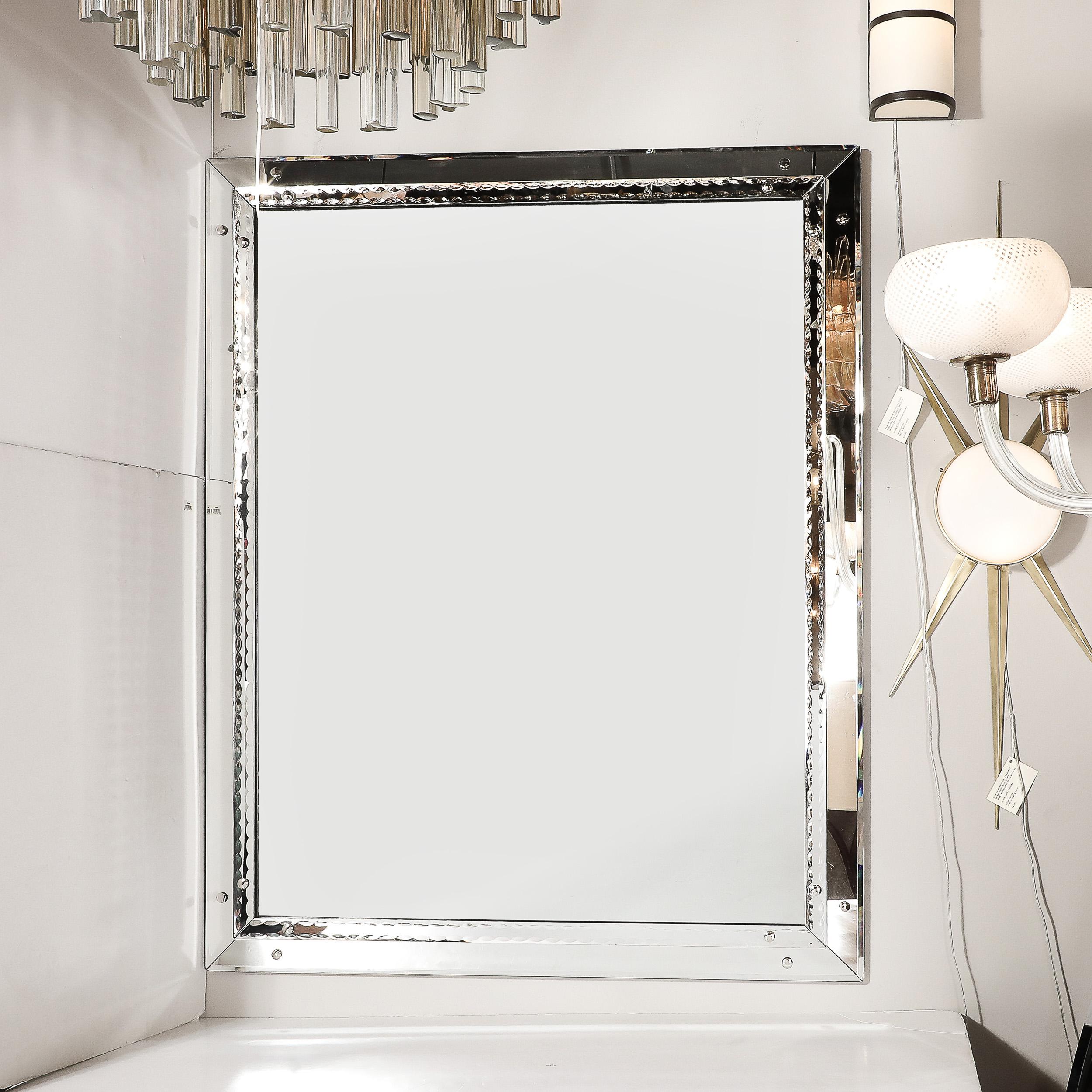 This Mid-Century Modernist Venetian glass mirror showcases the timeless artistry and craftsmanship synonymous with Italian design. Crafted circa 1950, its understated elegance is highlighted by a raised scalloped border, offering a refined sense of