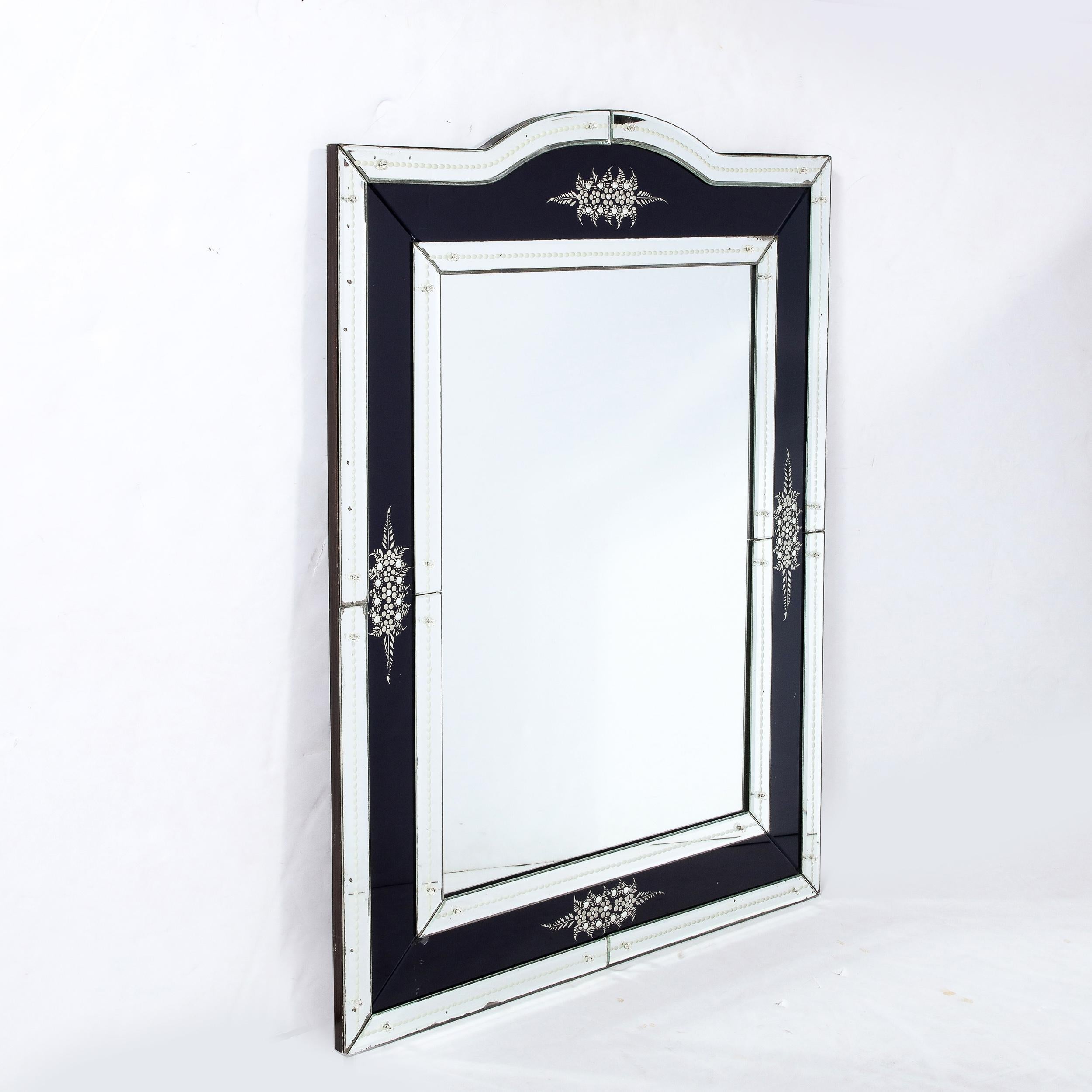 This Mid-Century Modernist Venetian Style Mirror with Reversed Etched detailing and inset virtolite Panels originates from France, Circa 1950. With a rectilinear profile and central arch form curve rising from the top panel, the mirror is adorned