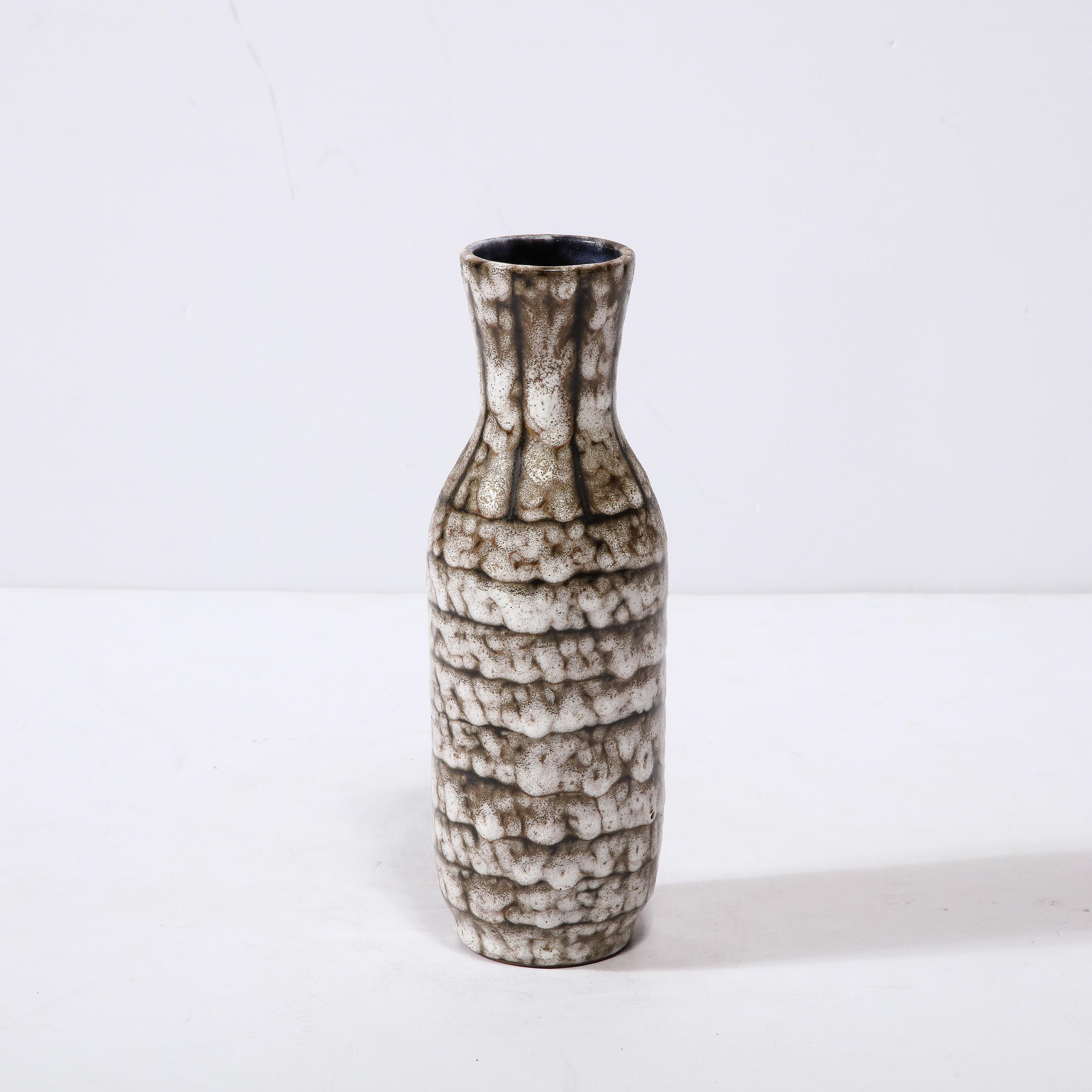 Ce vase en céramique moderniste du milieu du siècle avec des détails en bandes est un bel exemple de céramique européenne d'après-guerre, réalisé à Hódmezovasarhely Majolikagyár, en Hongrie, vers 1960. Avec une finition texturale étonnante composée