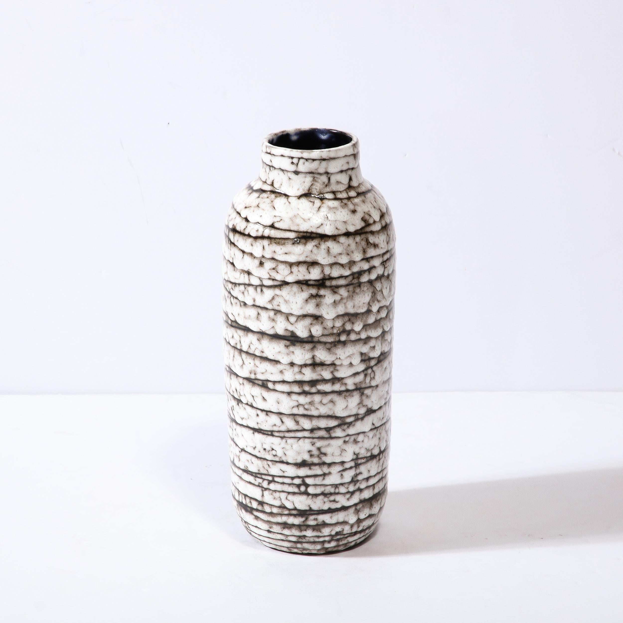 This Mid-Century Modernist Ceramic Vase is a beautiful example of Post War European Ceramics, realized in Hódmezovasarhely Majolikagyár, Hungary circa 1960. With a Stunning textural finish composed in Cream White and Blackened Umber, the surface of