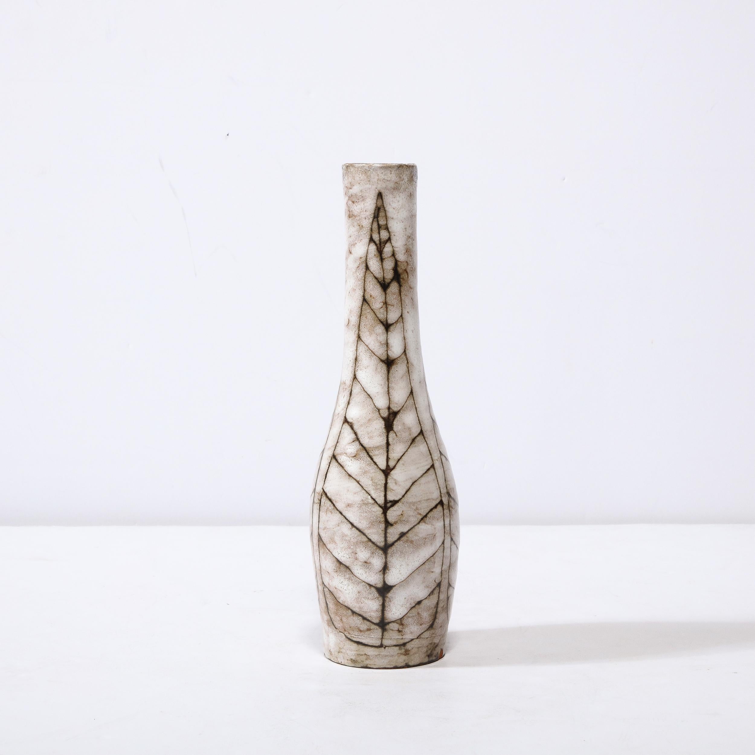 Ce vase fuselé en céramique du milieu du siècle avec motif de feuilles linéaires est un bel exemple de céramique européenne d'après-guerre, réalisé à Hódmezővasarhely Majolikagyár, Hongrie, vers 1960. Avec une finition texturale étonnante composée