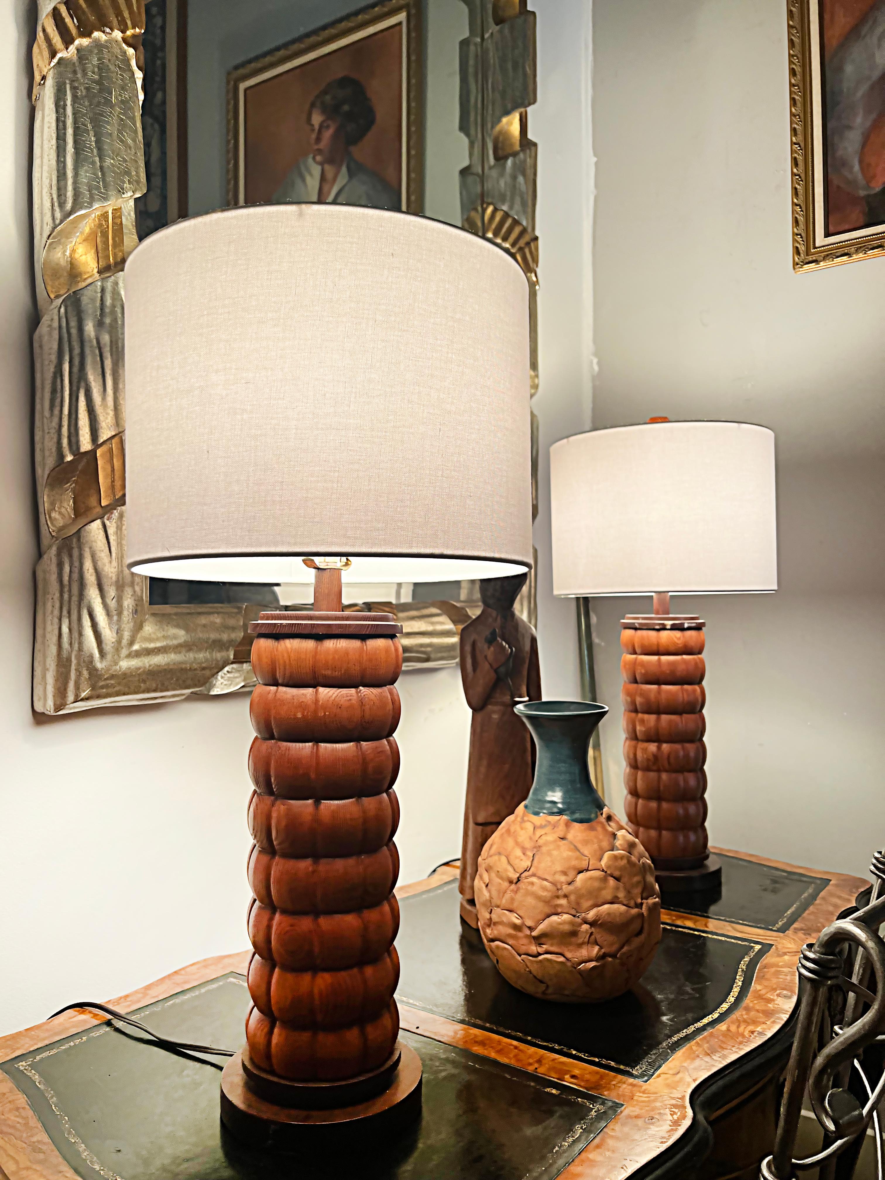 Mid-Century Modernist wood table lamps with new shades, pair.

Offered for sale is a pair of Mid-century Modernist carved wood column table lamps that have been fitted with new linen drum shades. They have brass sockets and harps. The height to