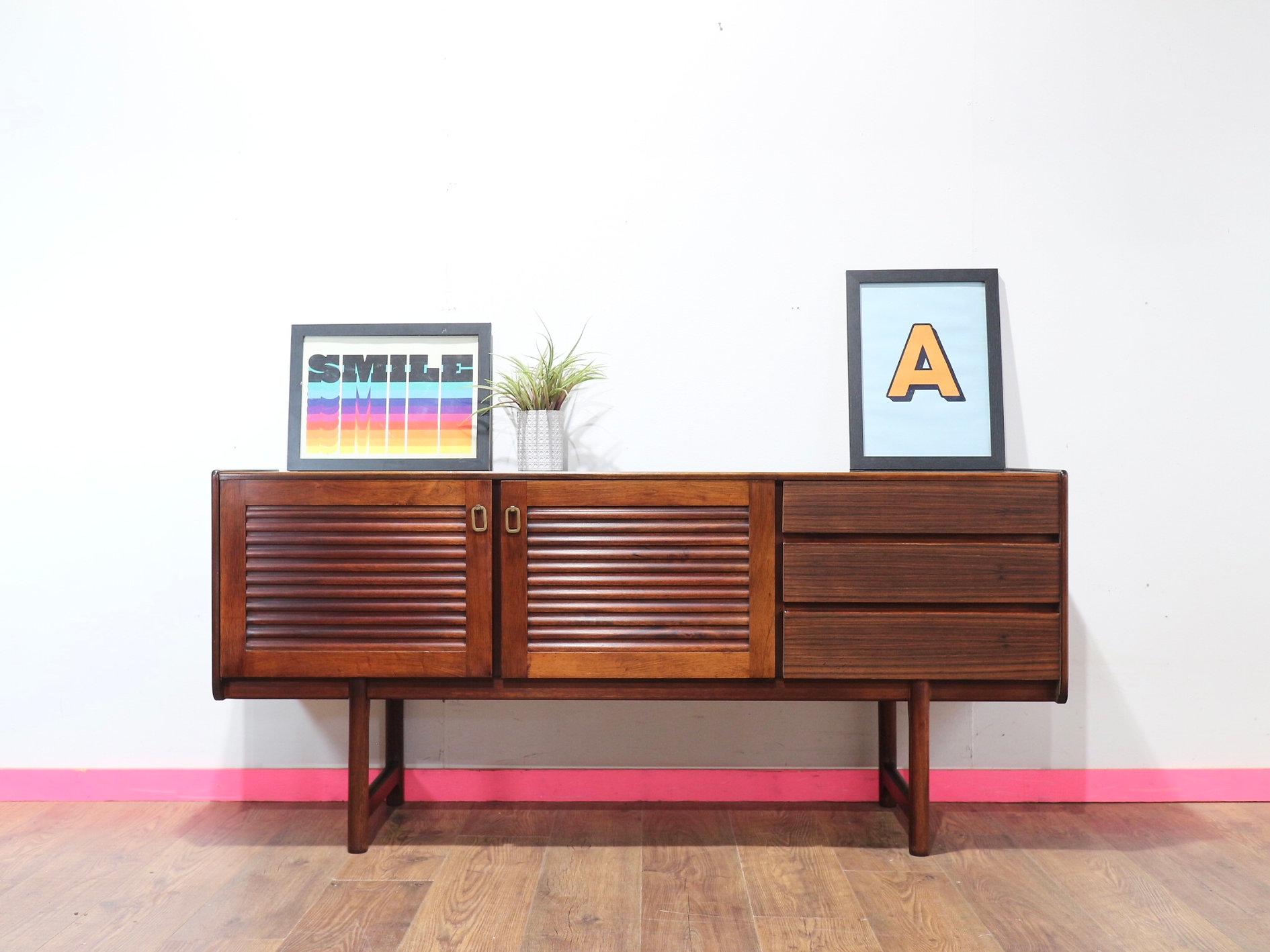 An eye catching mid century credenza by renowned British furniture maker A.H Mcintosh, this exceptional credenza made from Rosewood featuring louvered doors has plenty of storage but short enough to fit in small spaces. Perfect for any mid-century