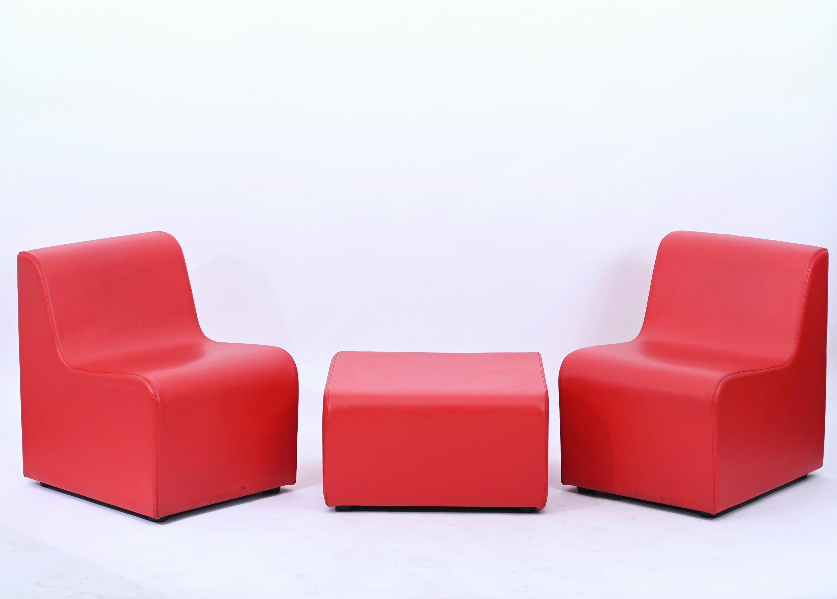 Beautiful red leatherette modular living room set composed by two chairs and a pouf. The set was produced in Italy in early 1980s.

The lines and colors of the chairs are typical example of 70s/80s furniture designs. The chairs can also be used as