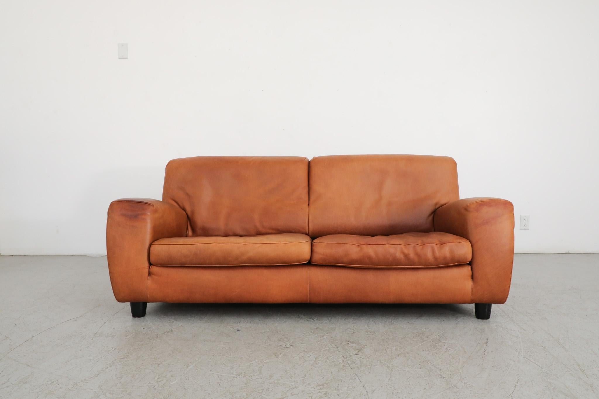 Mid-Century, thick and comfortable cognac colored leather loveseat. Manufactured with exceptional skill by renowned Italian leather specialist Molinari in high-end, thick and durable leather. Over the course of time the piece has acquired a deep,