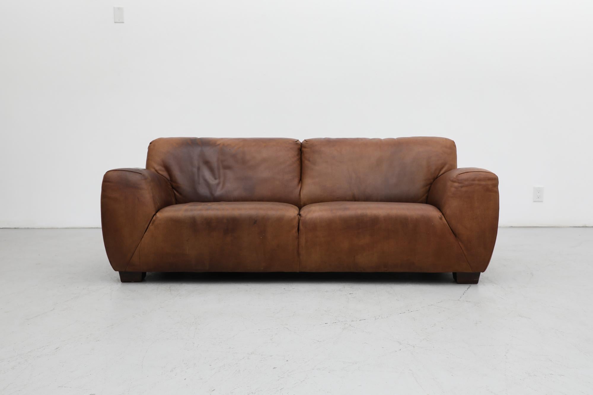 Mid-Century cognac leather sofa by Molinari Design, Italy. This sofa is made with high-end, thick and durable leather and that has sustained a beautiful patina. In original condition with heavy visible signs of wear including scratching and