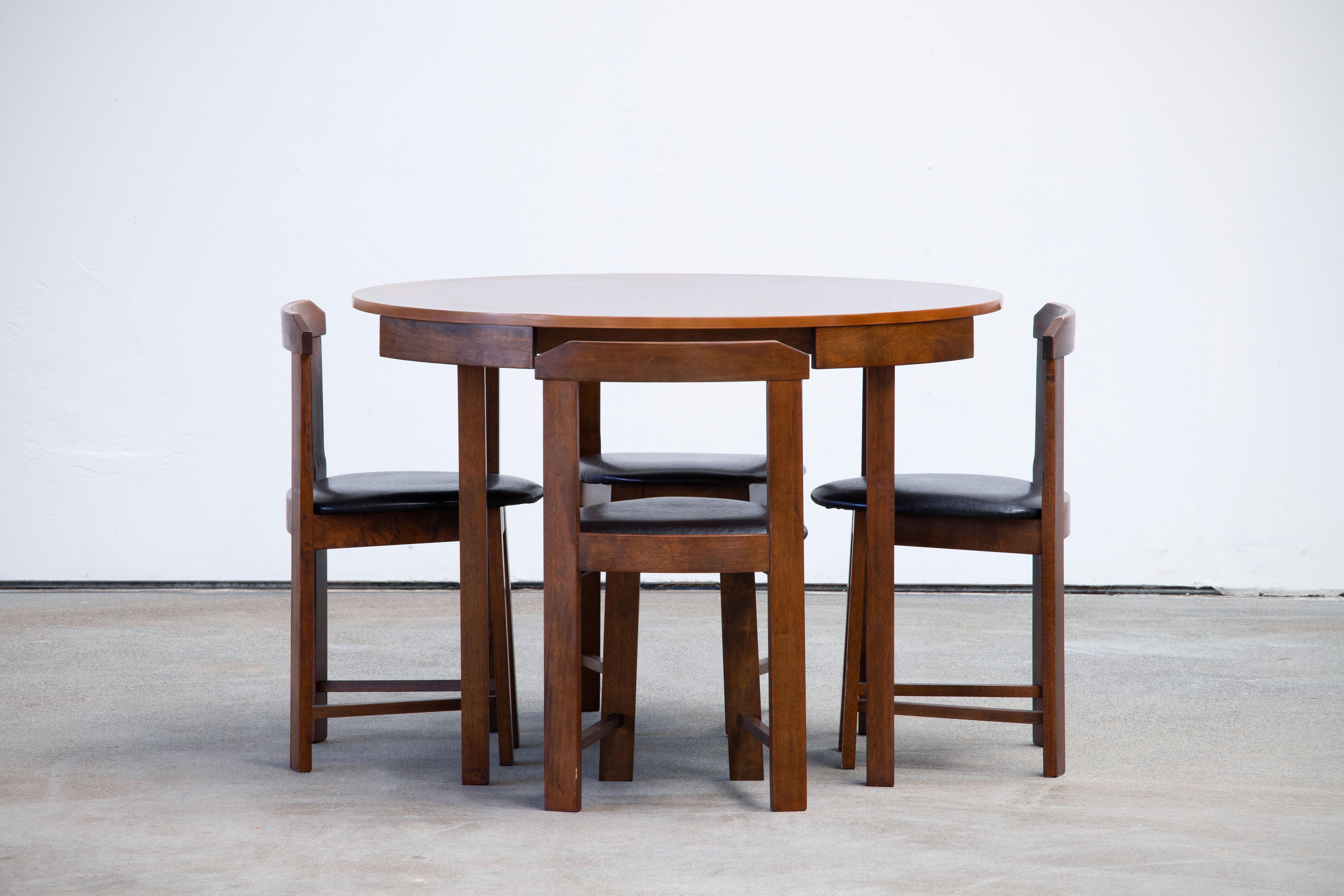 Scandinavian Modern designed, rare dining table and four chairs. The table accommodates four chairs neatly tucked around its outer rim.
It has been loving restored and polished.