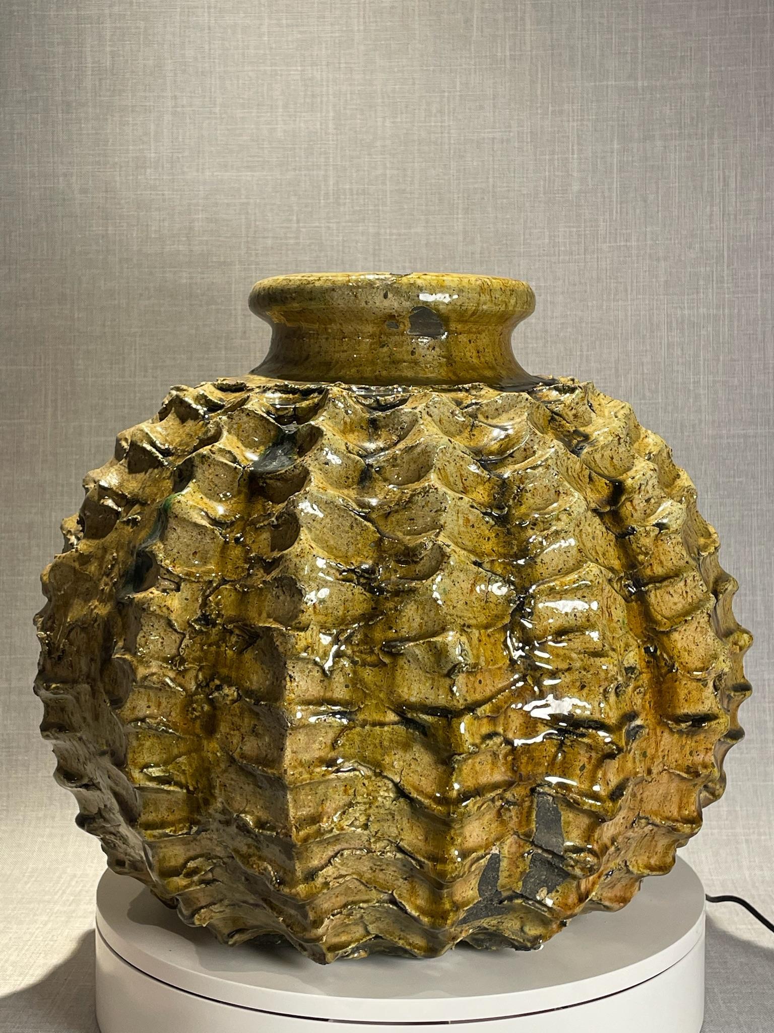 Diese unverwechselbare Studio-Keramikvase aus der Mitte des Jahrhunderts stellt eine bemerkenswerte Verschmelzung von Form, Textur und Kunstfertigkeit dar. Sein kühnes, skulpturales Design zieht sofort die Aufmerksamkeit auf sich, denn die