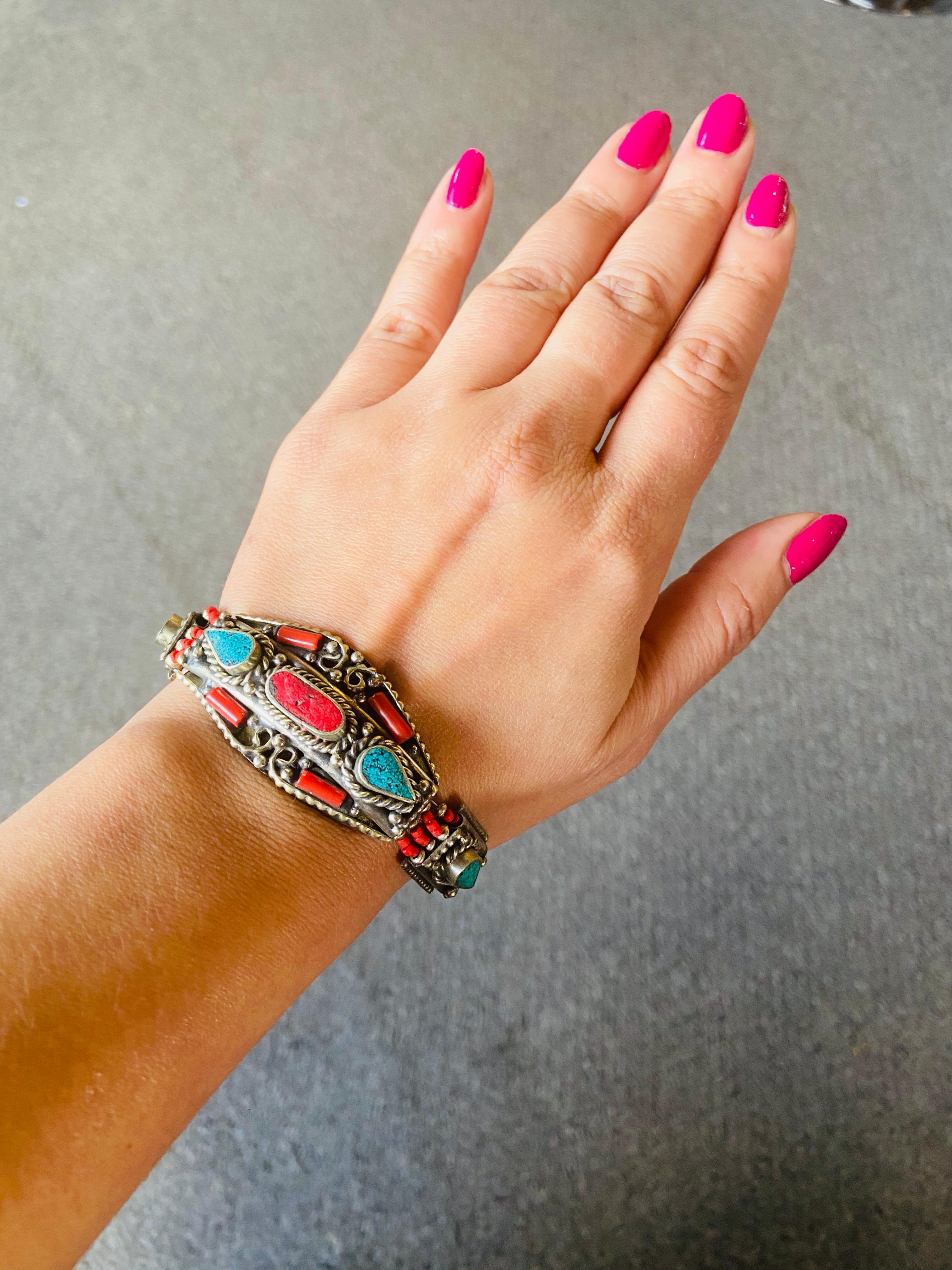 A stunning handmade Moroccan Berber tribal pure silver bracelet. This beautiful and one of a kind piece of jewelry made around 1950's in the Atlas Mountains in Morocco features genuine turquoise and red natural stones , all shaped in impressive
