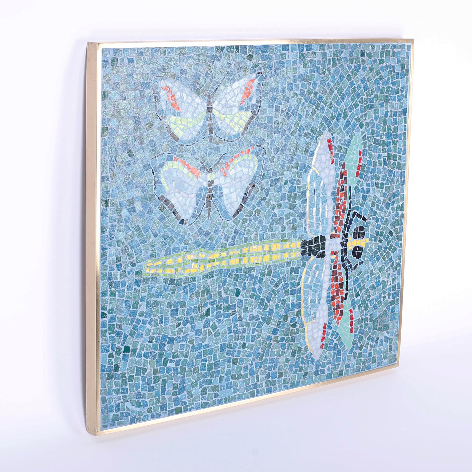 Spirited wall plaque with two stylized butterflies and a dragonfly depicted in mosaic tile in an alluring blue background with a lacquered brass frame. A pair of mosaic butterfly tables are also available, as seen in the last photo of the listing.