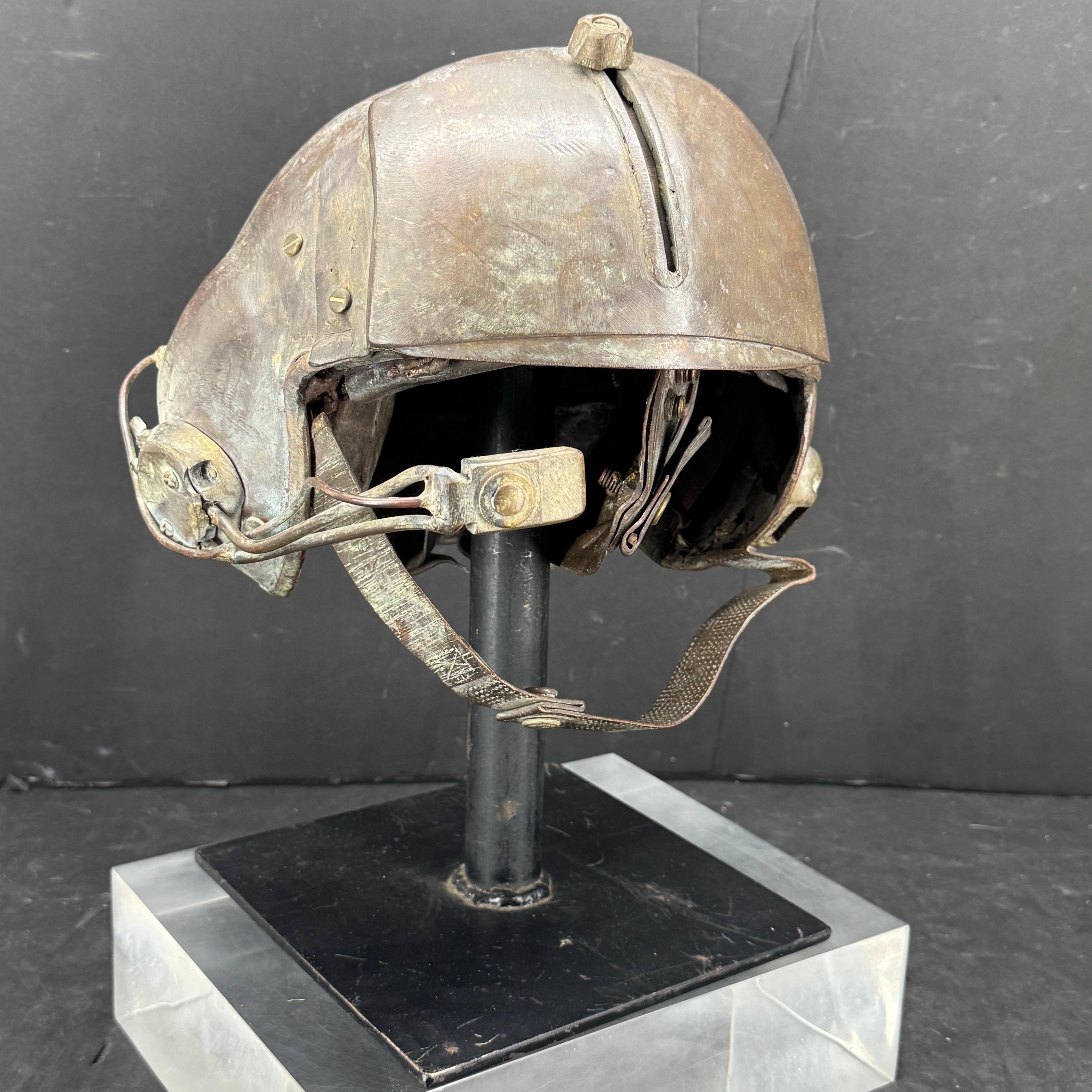 Escultura de bronce macizo de mediados de siglo de un casco militar estadounidense. Creemos que se trata del casco de un helicóptero de ataque del Ejército. El casco es muy pesado y se asienta sobre un soporte de acero pintado de negro.

 