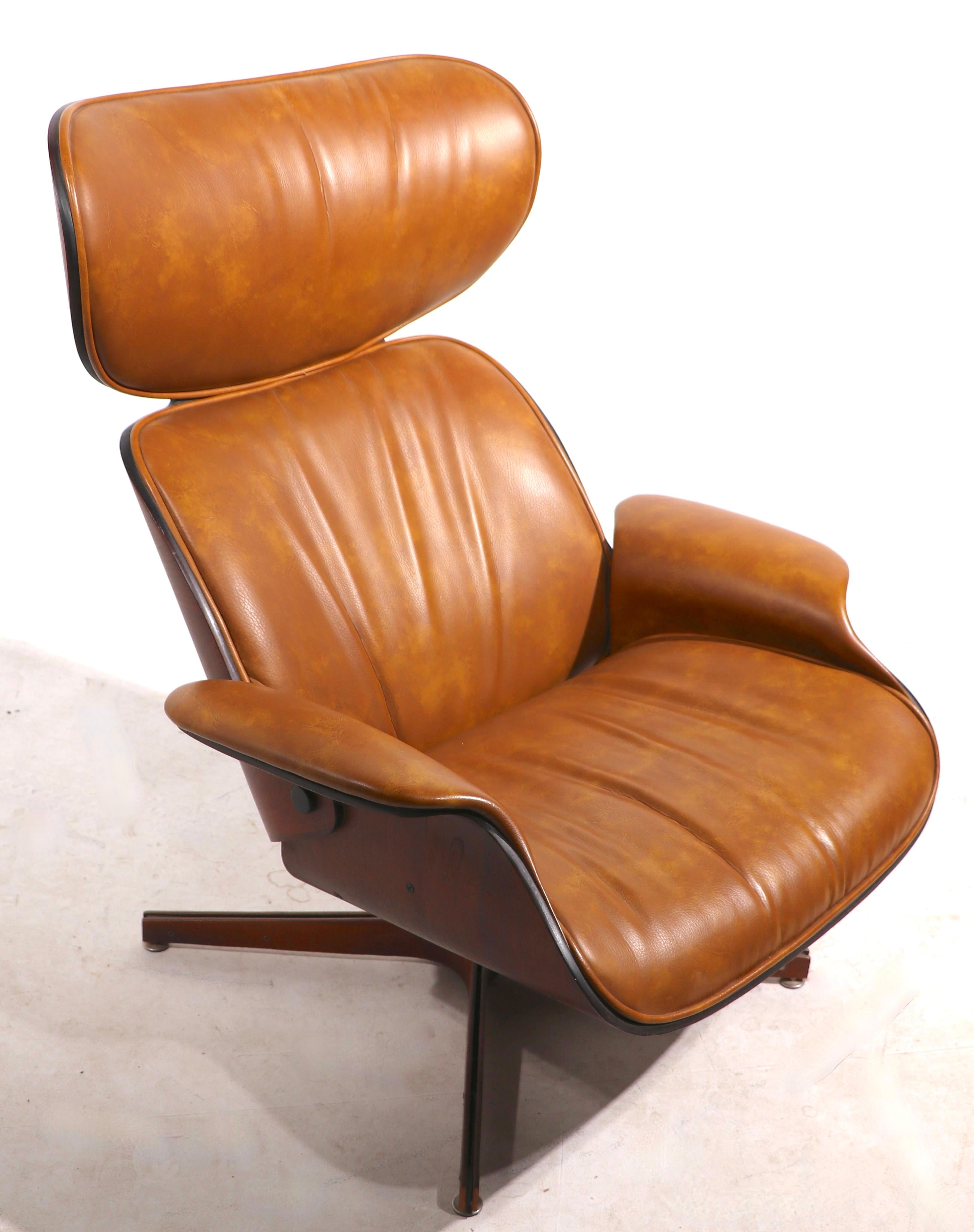 Iconic mid century swivel tilt lounge chair and ottoman designed by George Mulhauser for Plycraft. Sculptural bent ply shell, with vinyl upholstery. This example is in very fine, original condition, clean and ready to use. 
 Chair dimensions:
