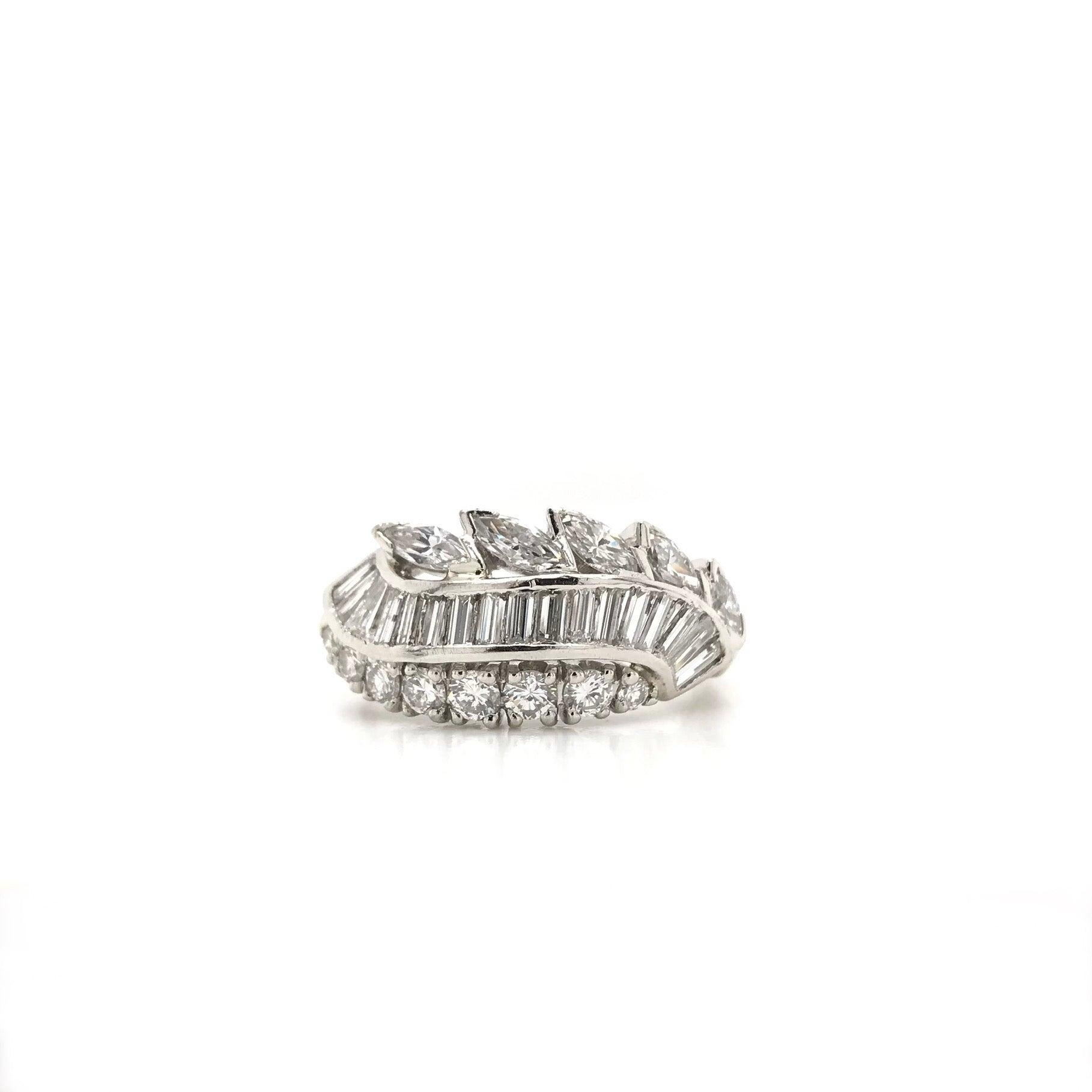 This vintage piece was crafted sometime during the Retro design period (1940-1960). This stunning vintage ring features 30 sparkling diamonds in three different cuts arranged for a very striking and alluring combination. The ring features 5 marquise
