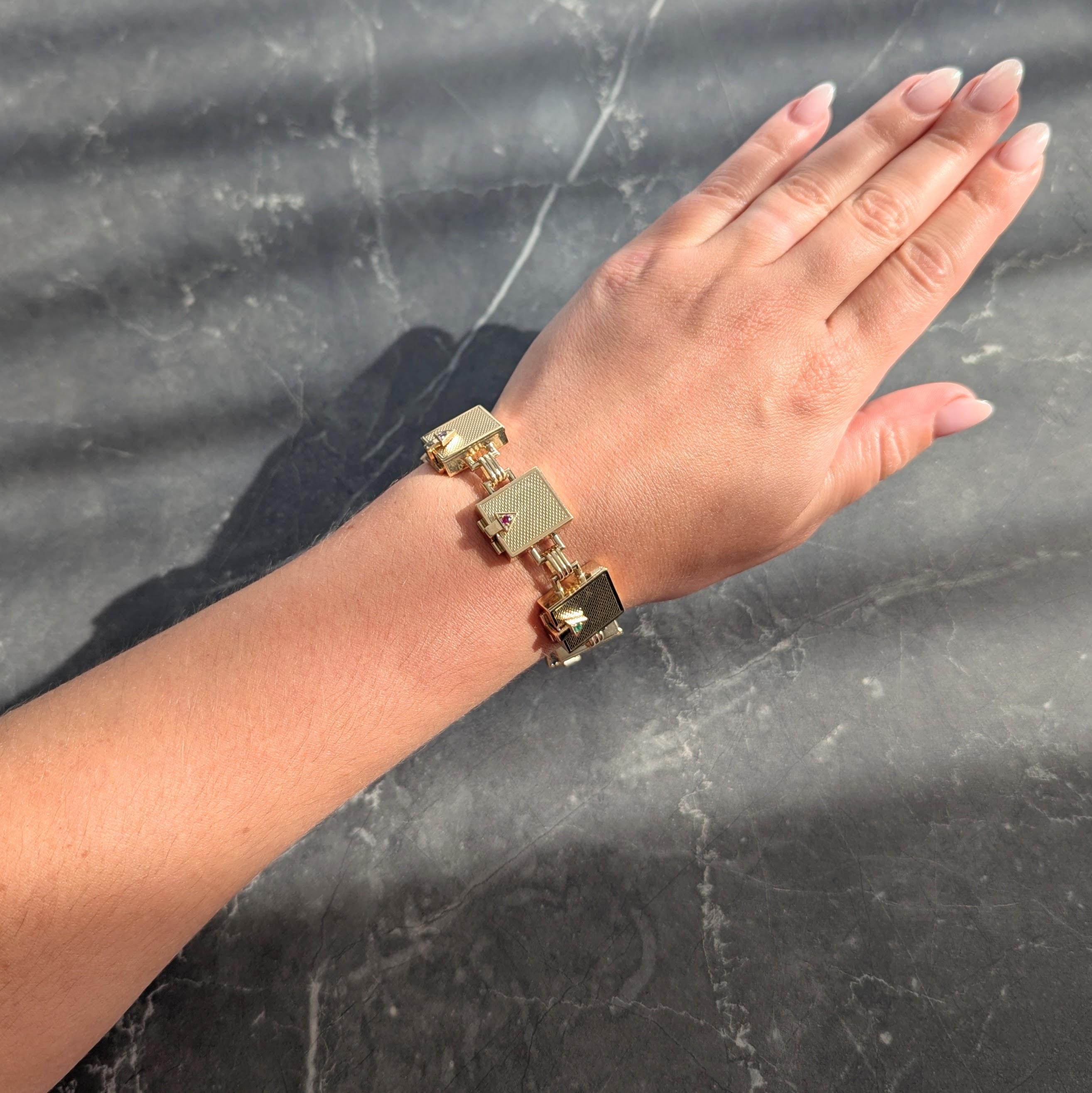 Comprised of fluted bar links alternating with rectangular box links
Each is grooved with weave texture on top with high polish edges
Featuring hinged locking closures with triangular terminals
Each bead set with acrostic gemstones spelling