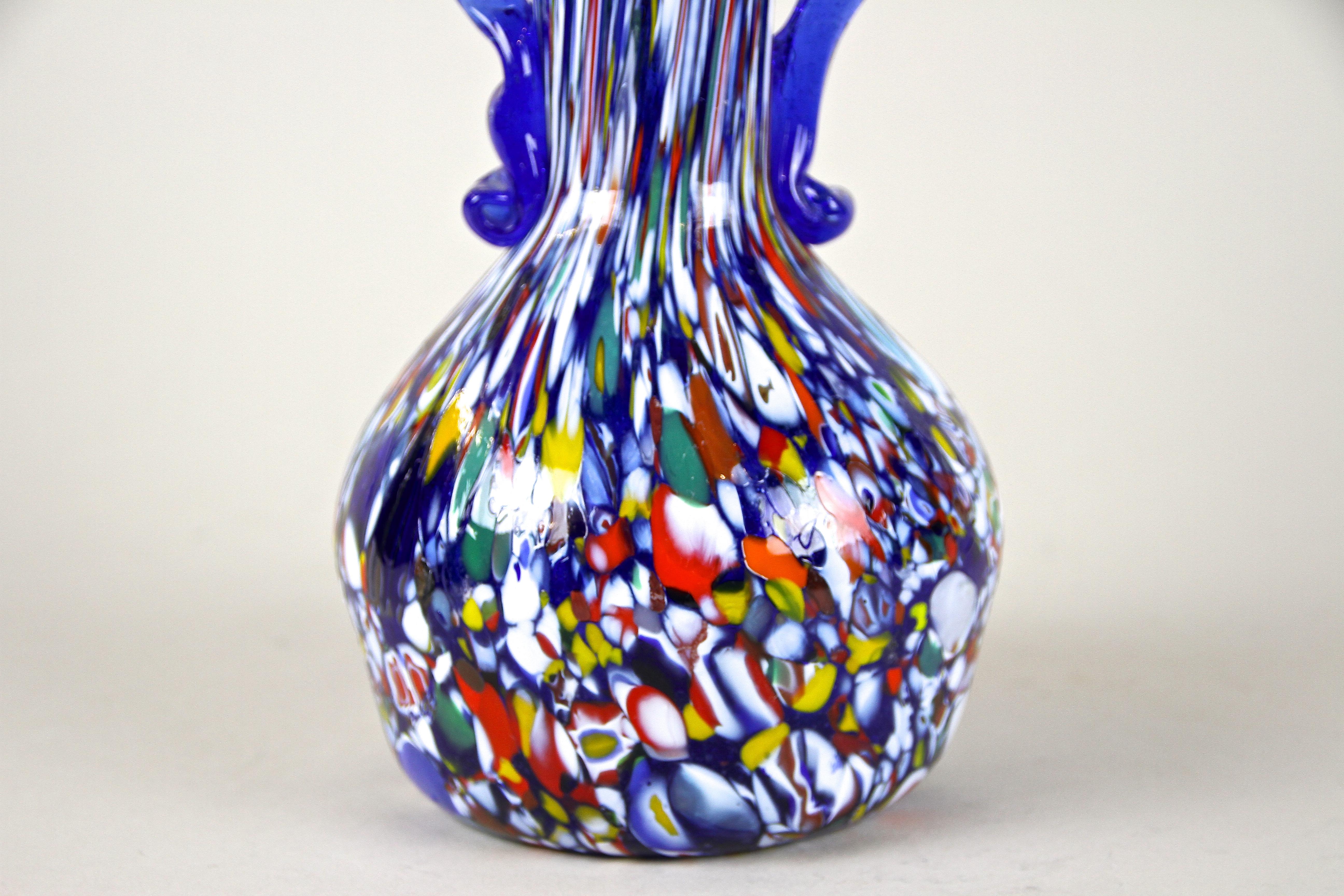 Colorful, unusual Murano glass vase from the workshops of Fratelli Toso around 1940/50. Elaborately hand crafted in the mid 1900s on the island of Murano, this unusual piece of glass art impresses with a beautiful shaped, dark blue core body adorned