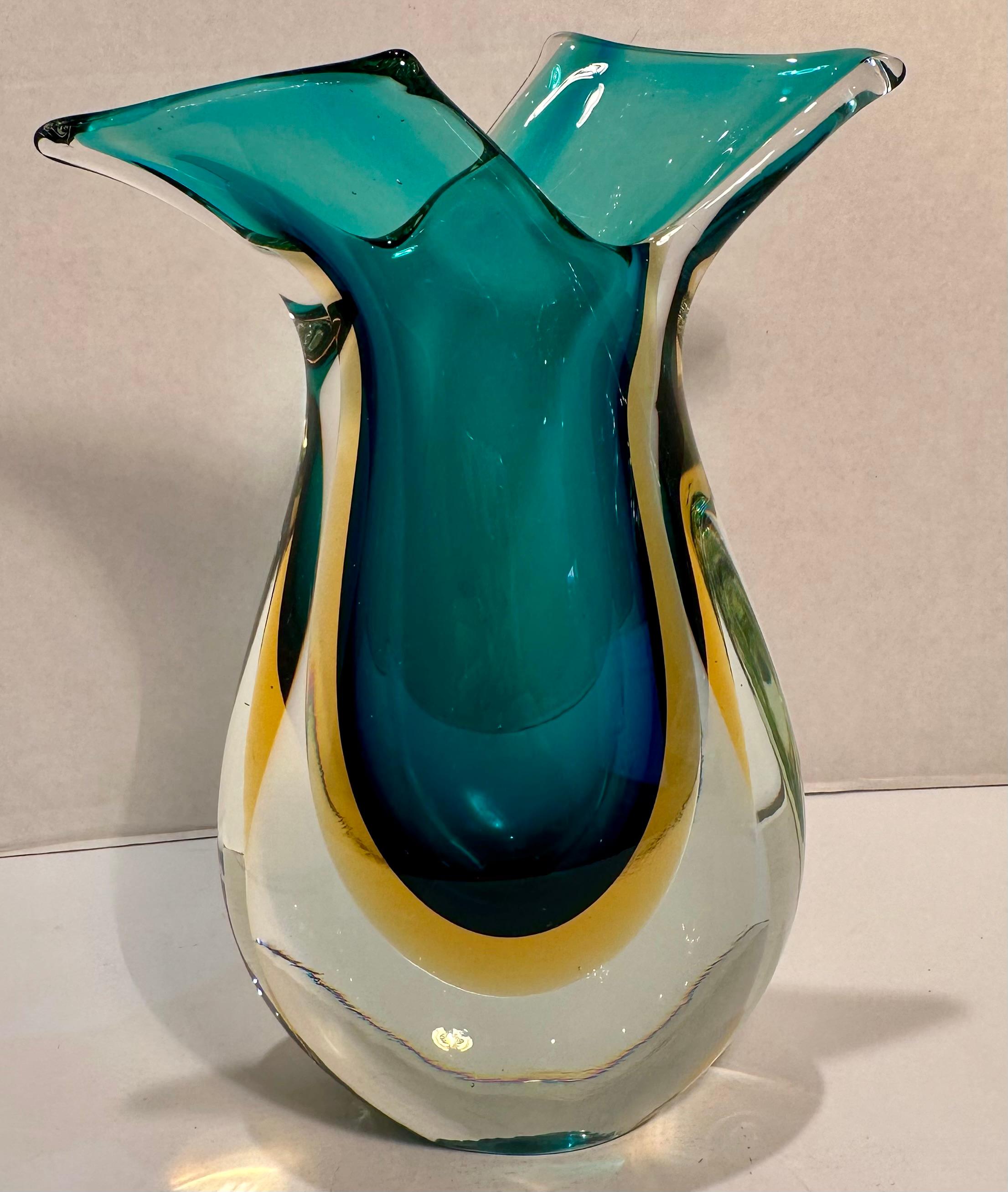 Very striking, hand made and mouth blown in Italy, mid-century Murano art glass sommerso vetro curving vase in vibrant shades of aqua blue color with rich golden yellow center.  The word 