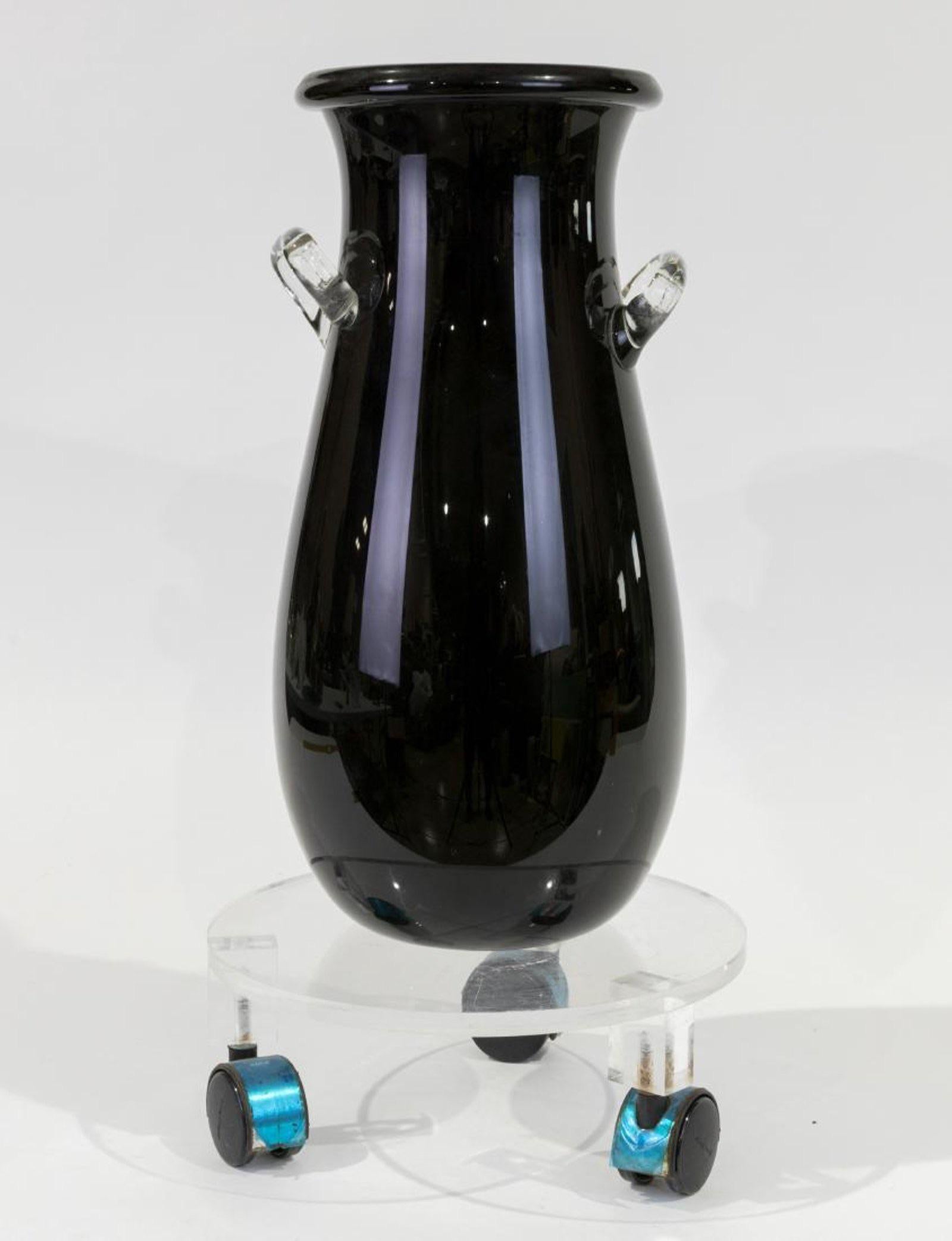Mid-late 20th century Postmodern Murano art glass floor vase amphora, blue-black, handled, round lip.
Gorgeous Postmodern take on the classical tradition: A large Murano glass krater in deep blue / black on a luminous Lucite base with casters.