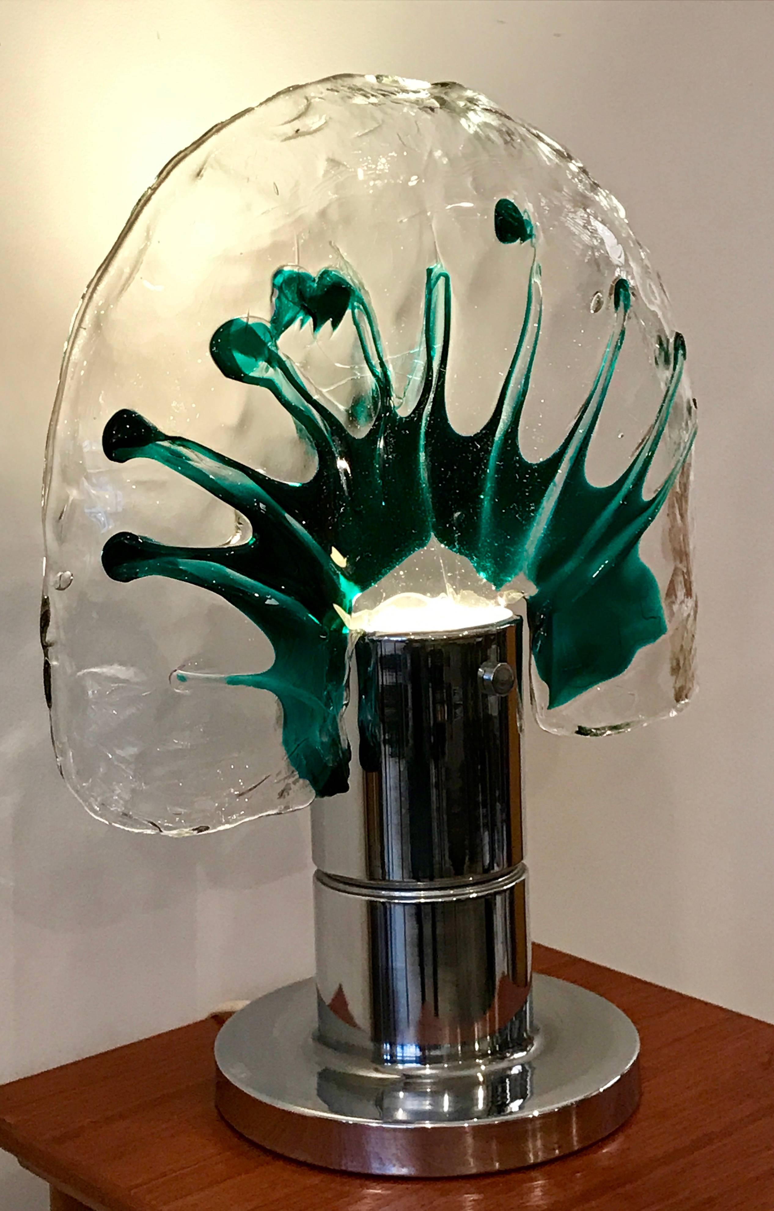 Very unusual handblown Murano art glass shape mounted on chrome cylinder base. Thick clear glass with vibrant green accents.