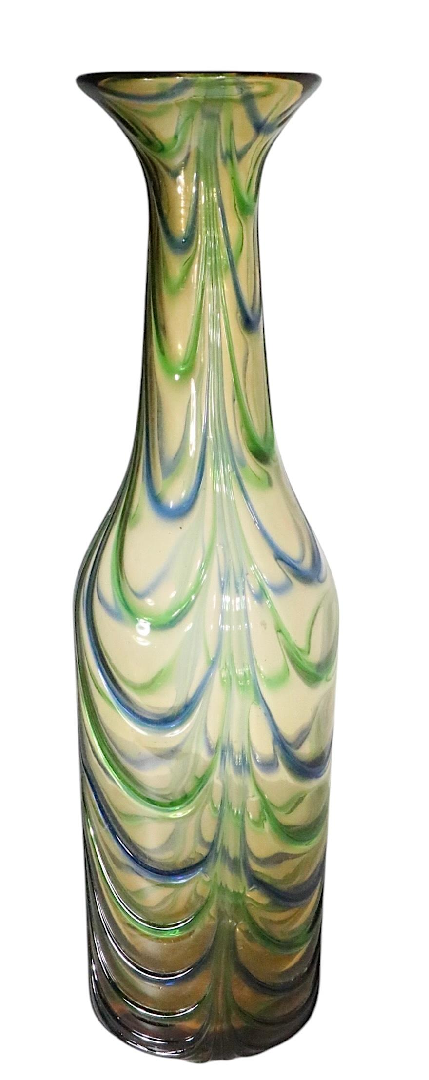 Excepcional jarrón de cristal artístico de Murano, con fondo de cristal ámbar y adornos drapeados aplicados en hilos de cristal azul y verde alternados. El jarrón en forma de botella está en excelente estado, original, limpio y listo para usar, sin