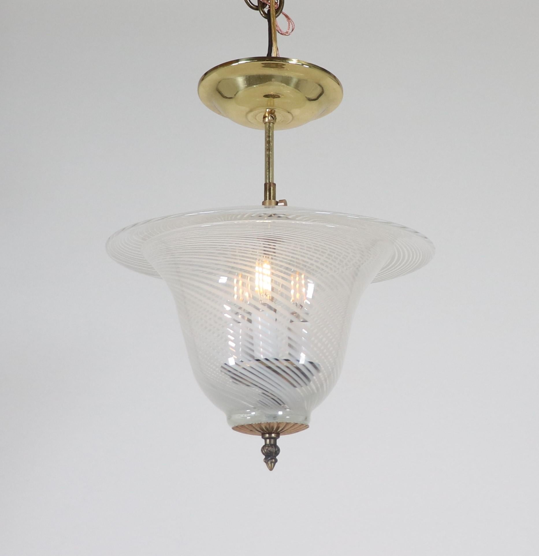 Questa plafoniera di Murano della metà del secolo scorso è ornata da delicate strisce bianche e sottili. La forma di questo apparecchio ricorda una lanterna coperta e le spirali creano morbidi motivi sulla parete quando vengono illuminate.

Le