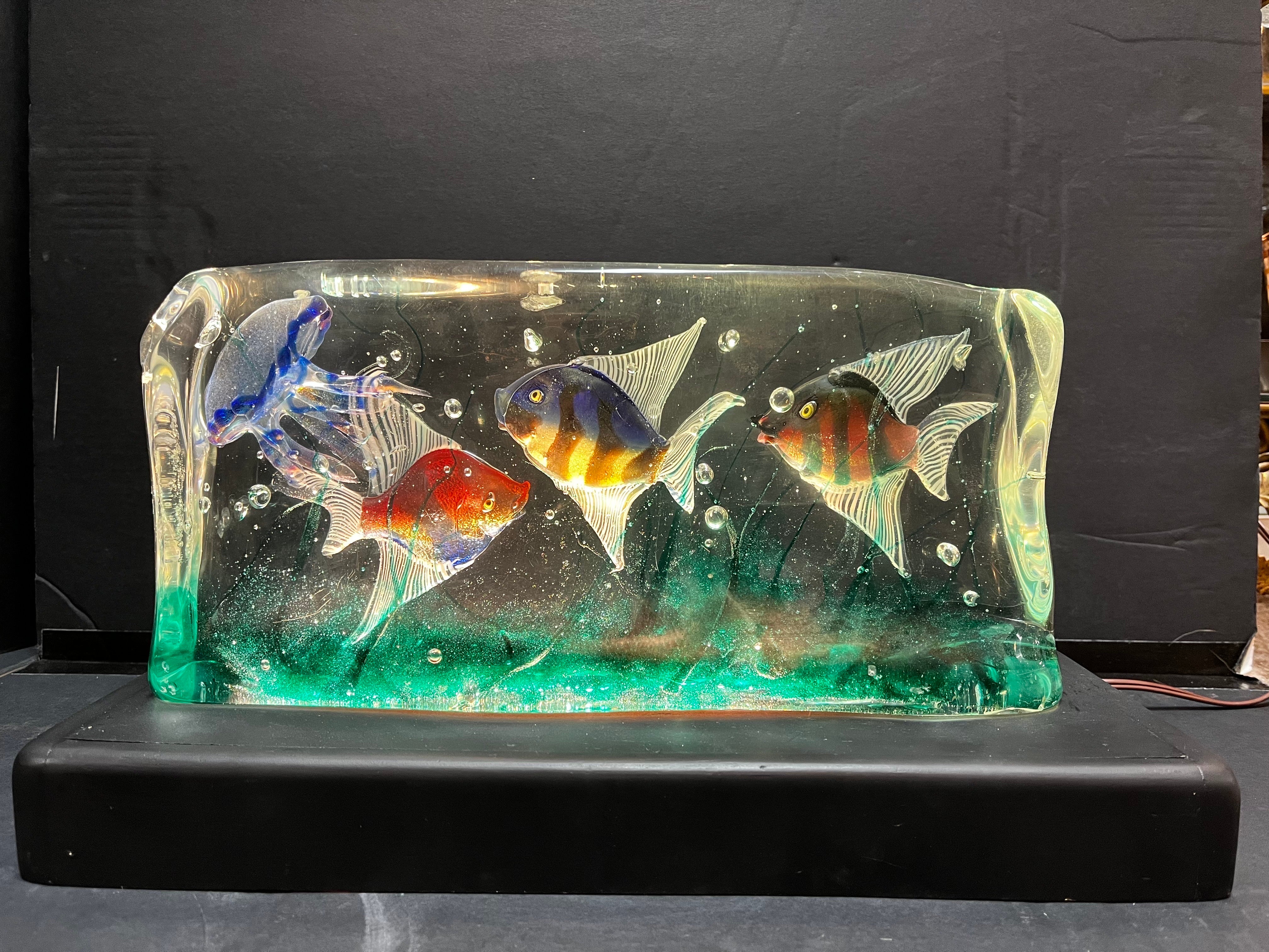 A large Mid-Century Modern era Murano glass fish and jellyfish aquarium sculpture presented as a table light on a vintage custom made wood base. The base has been recently painted and the piece rewired. The Murano glass aquarium is in the style of
