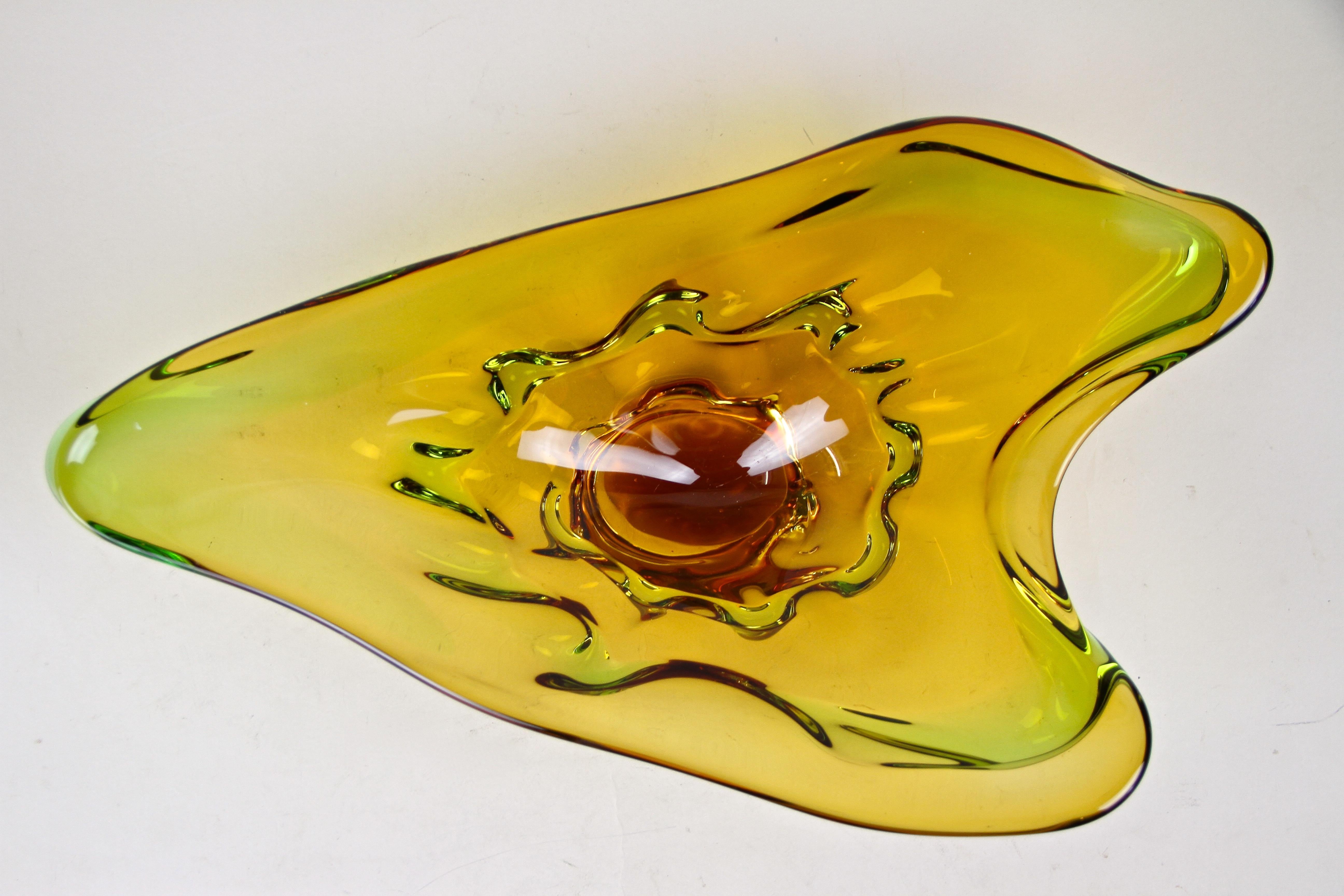 Exceptional murano glass bowl out of the famous workshops in Italy from the era around 1960/70. Colored in beautiful amber and green tones, this large, unusual shaped glass bowl impresses with its amazing design. The highly decorative murano bowl