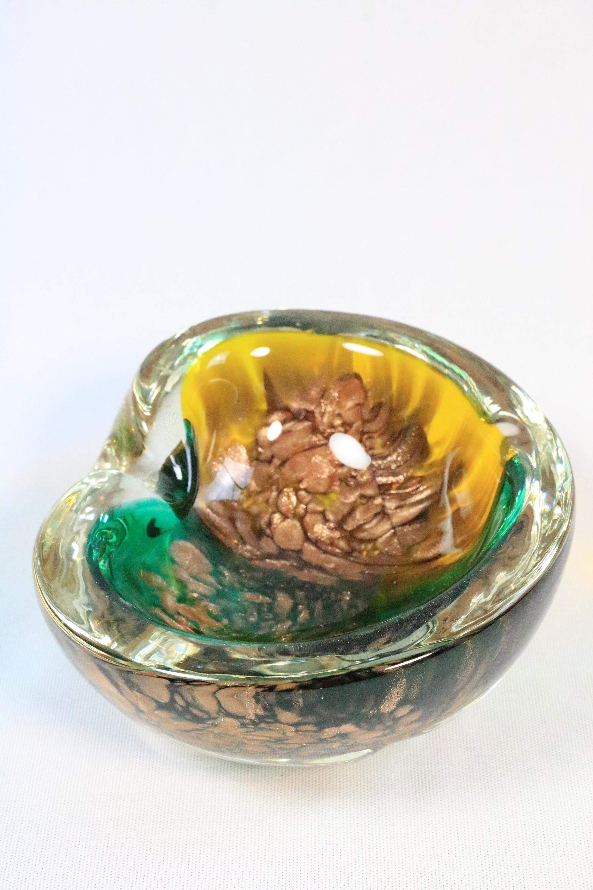 Petit bol ou cendrier très décoratif en verre de Murano.
Détails décoratifs en paillettes dorées.

Rare et belle combinaison de couleurs.
Fabriquées en Italie.

Longueur : 16 cm
Profondeur : 14 cm / 5.5 inches
Hauteur : 6 cm

Très bon état.

