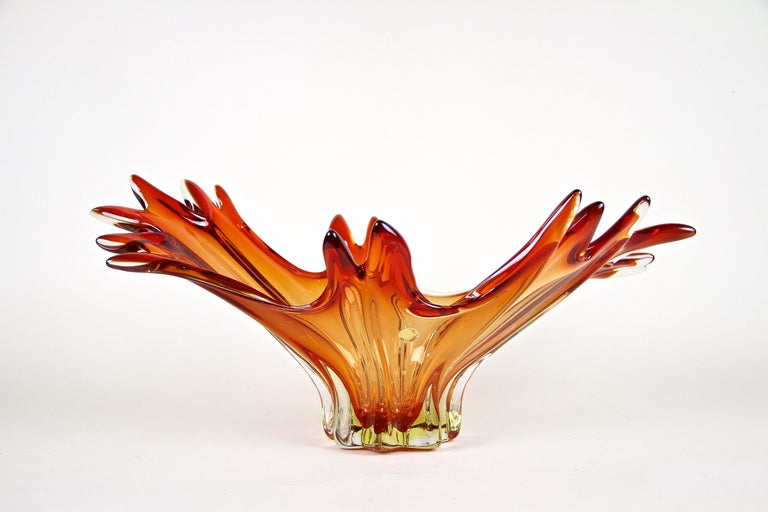 Fantastic looking Murano glass bowl out of the renown workshops of Sommerso from the little island of Murano in Italy around 1960/70. Colored in amazing shining red and orange tones, this unique large glass bowl or centerpiece impresses with an