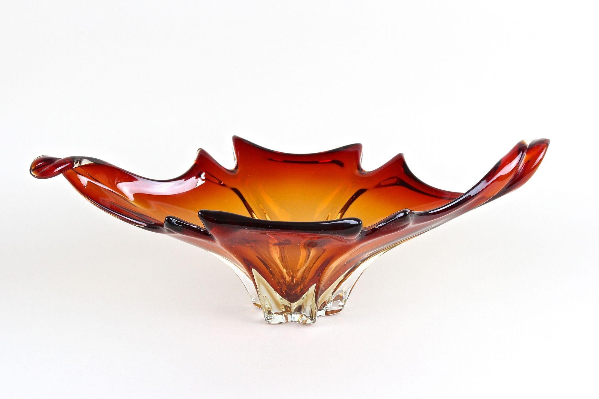Very decorative large Murano glass bowl out of the renown workshops in Italy from the mid century period around 1960/70. Impressing with its extraordinary shape - just see the gorgeous curled ends - and amazing design in lovely red and orange tones,
