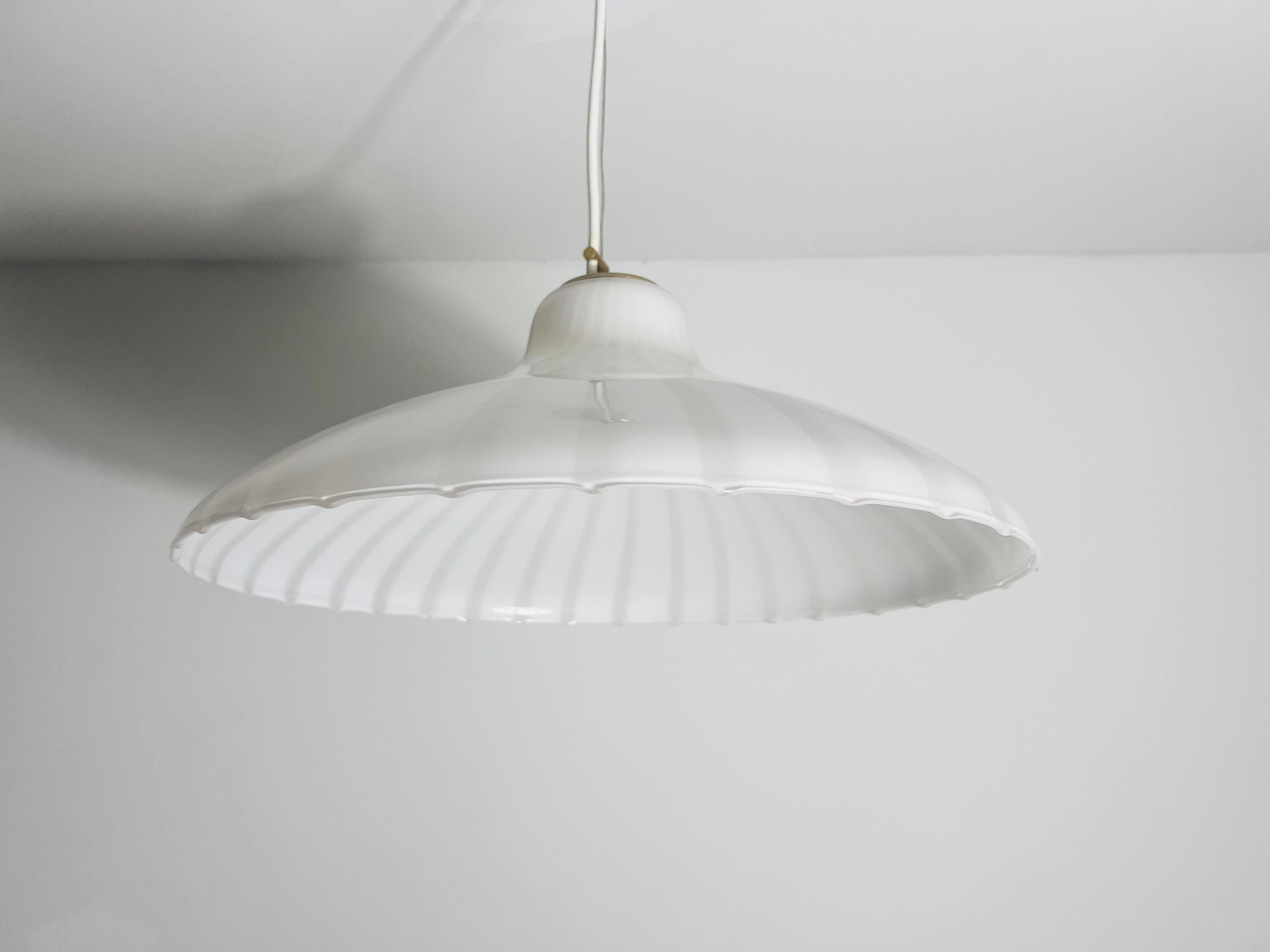 Exquisite Murano glass ceiling lamp from Italy, dating back to the 1960s. This stunning piece is made from hand-blown Murano glass with a delicate white hue, further enhanced by intricate white stripes embedded within the glass. The meticulous