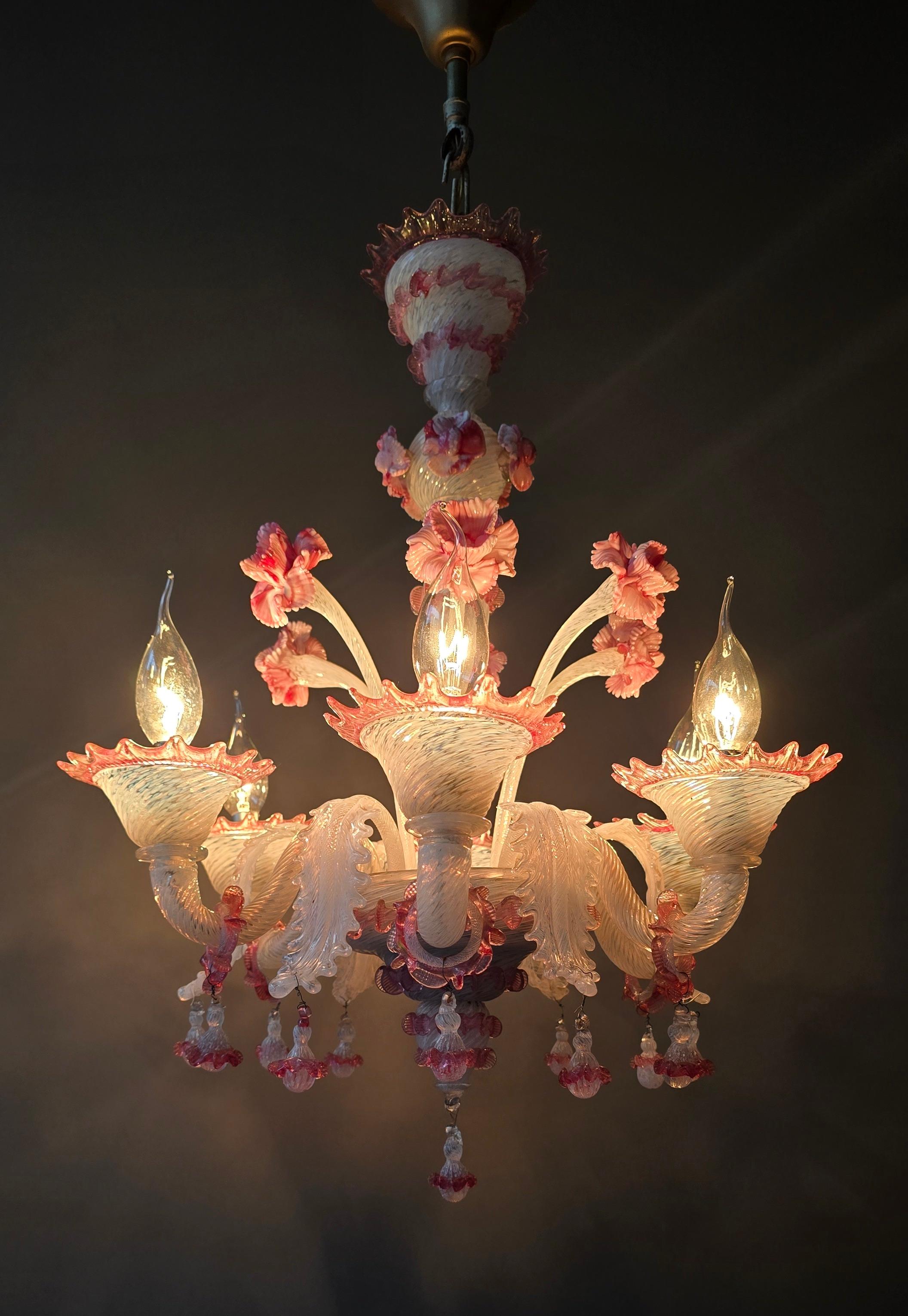 Ein raffinierter Kronleuchter aus Murano-Glas aus der Mitte des Jahrhunderts, mundgeblasen in Italien, ca. 1950-1960. Das durchscheinende weiße Glas weist eine zarte, gedrehte Gitterstruktur auf, die mit zartrosa Akzenten und reich modellierten