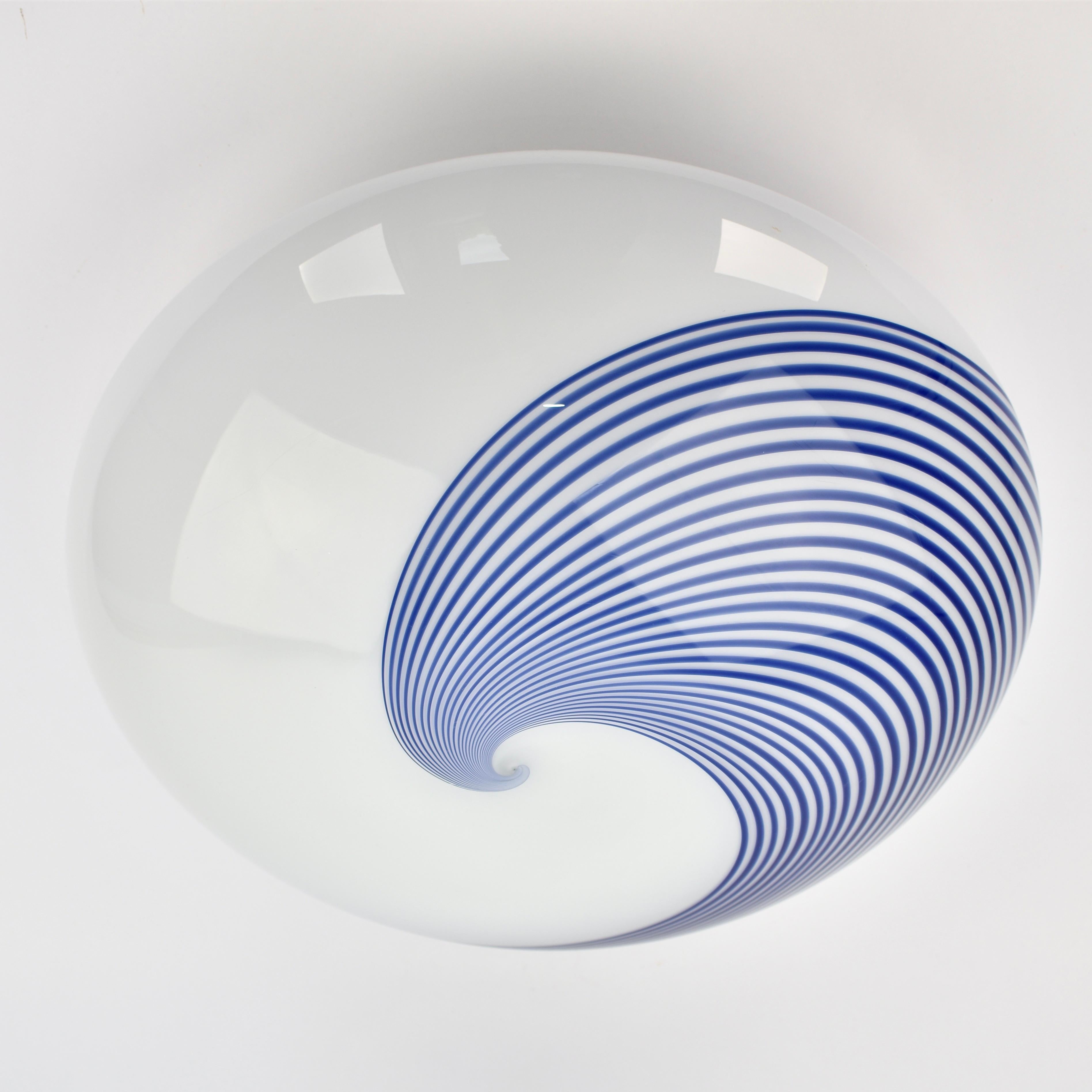 Bring bold retro charm into your space with this stunning Mid-Century Murano glass flush light, featuring an eye-catching cobalt blue and white swirl design. Handblown in Italy, this piece captures the timeless style of Venini and Vignelli. The lamp