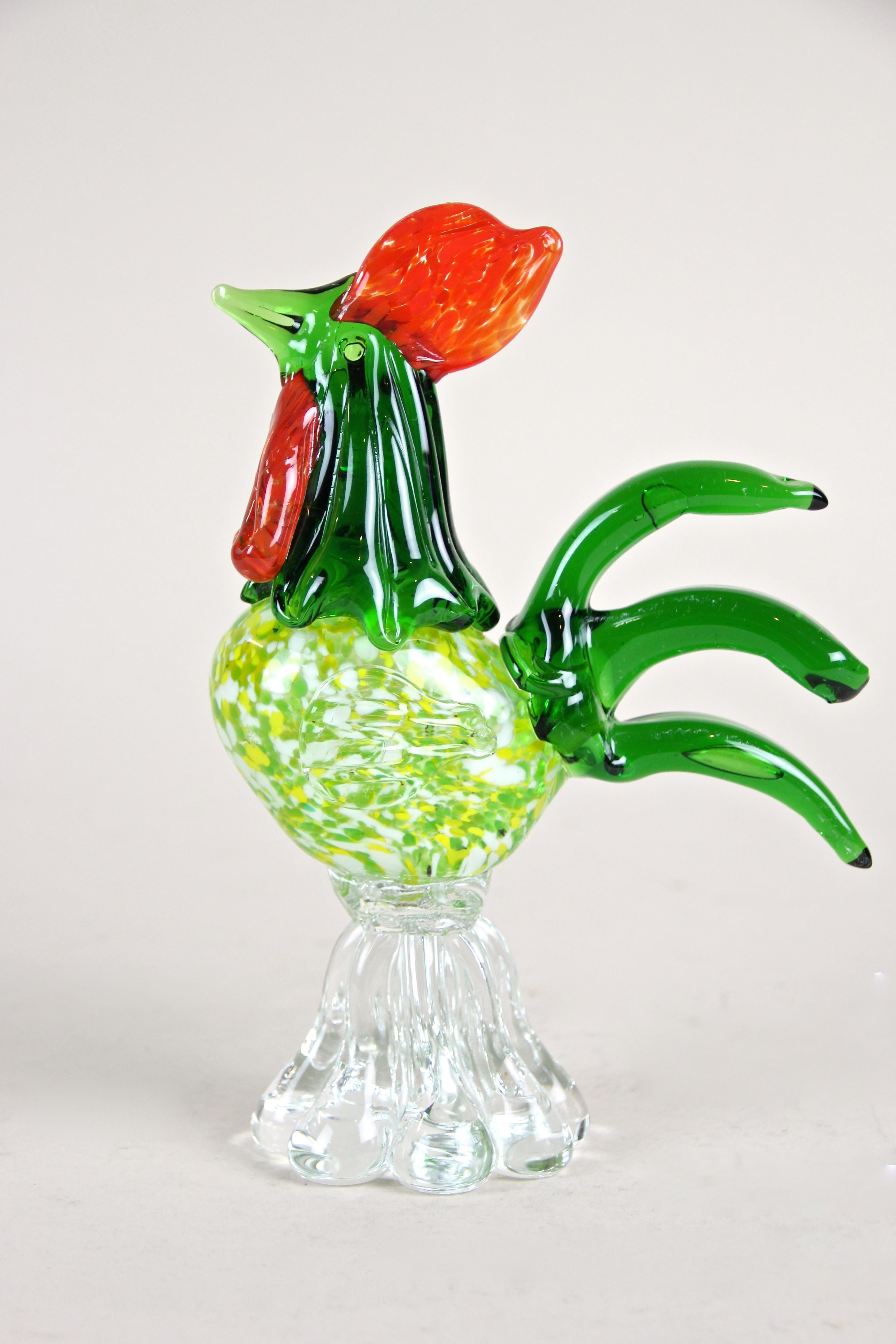Fantastic handcrafted midcentury Murano glass art cock out of the renown Murano workshops in Italy from circa 1950. The multicolored in-glas worked body shows beautiful green and yellow tones and just looks gorgeous. Standing on a clear glass base