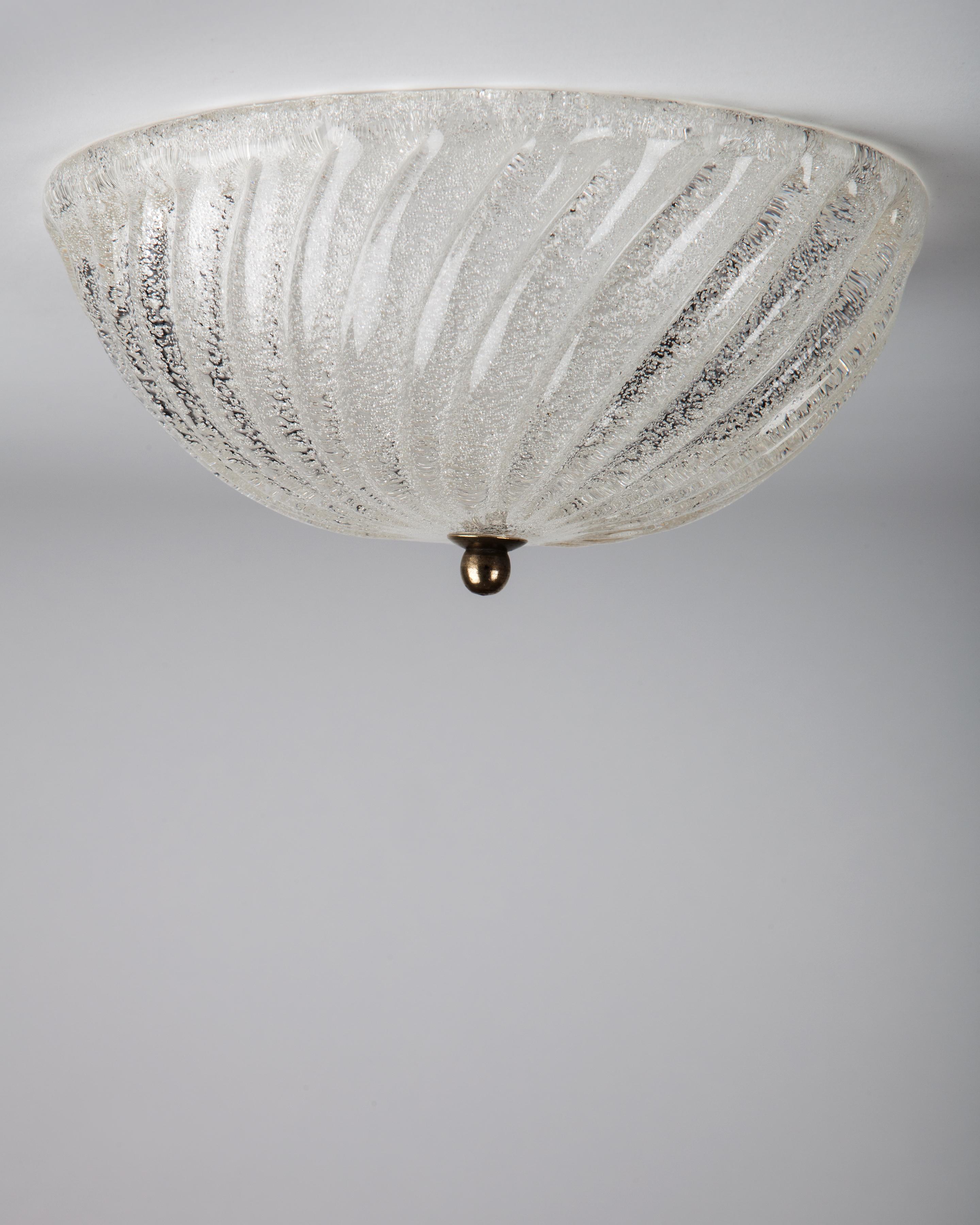 A vintage swirled and textured Murano glass dome flush mount with an aged brass finial. Due to the antique nature of this fixture, there may be some nicks or imperfections in the glass as well as variations from piece to piece, circa