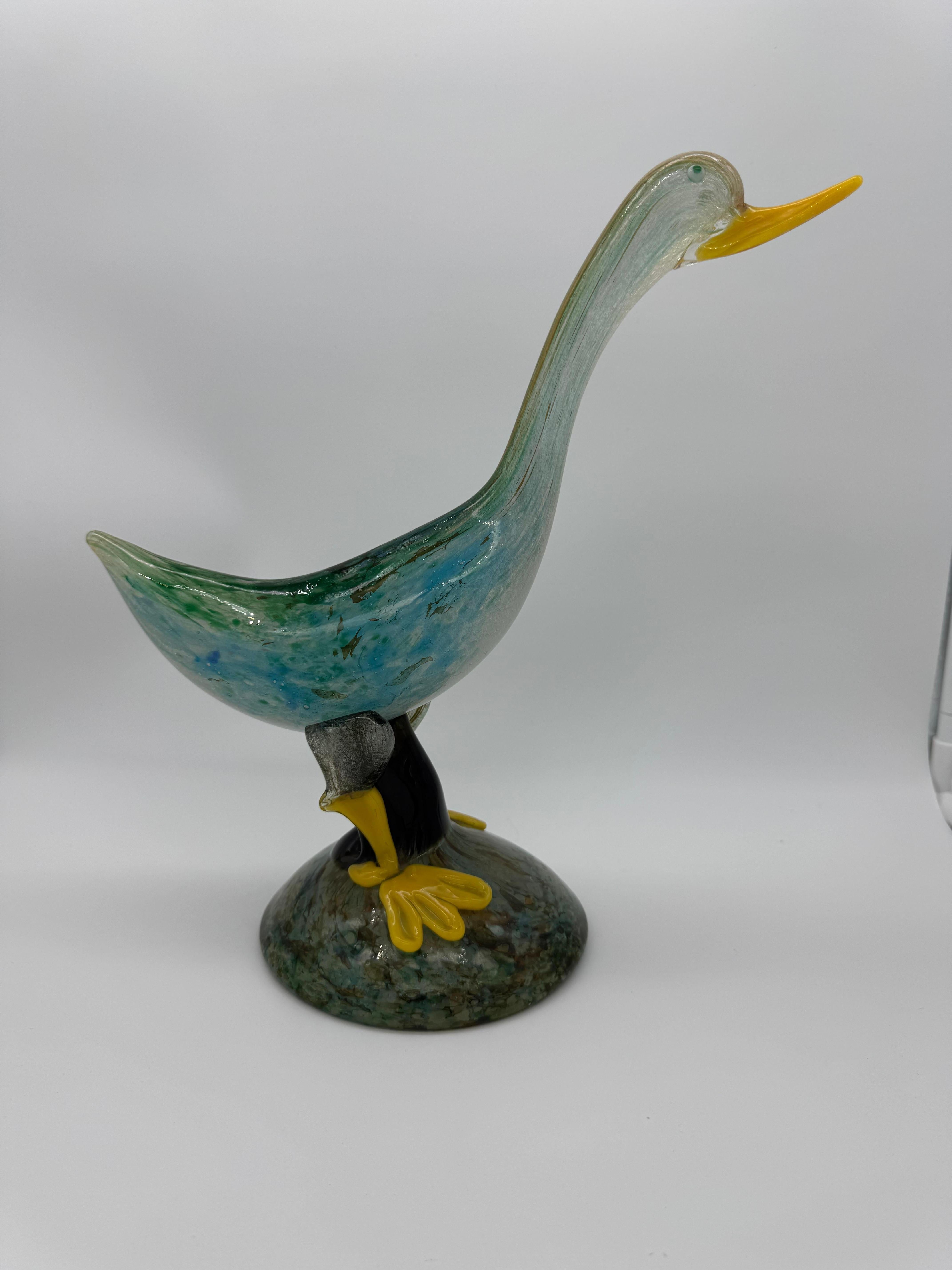 Immergiti nell'arte del vetro di Murano con questa splendida anatra, testimonianza dell'eccezionale maestria della prestigiosa vetreria di Aureliano Toso. Attribuito al famoso designer Dino Martens, questo pezzo incarna lo spirito innovativo e la