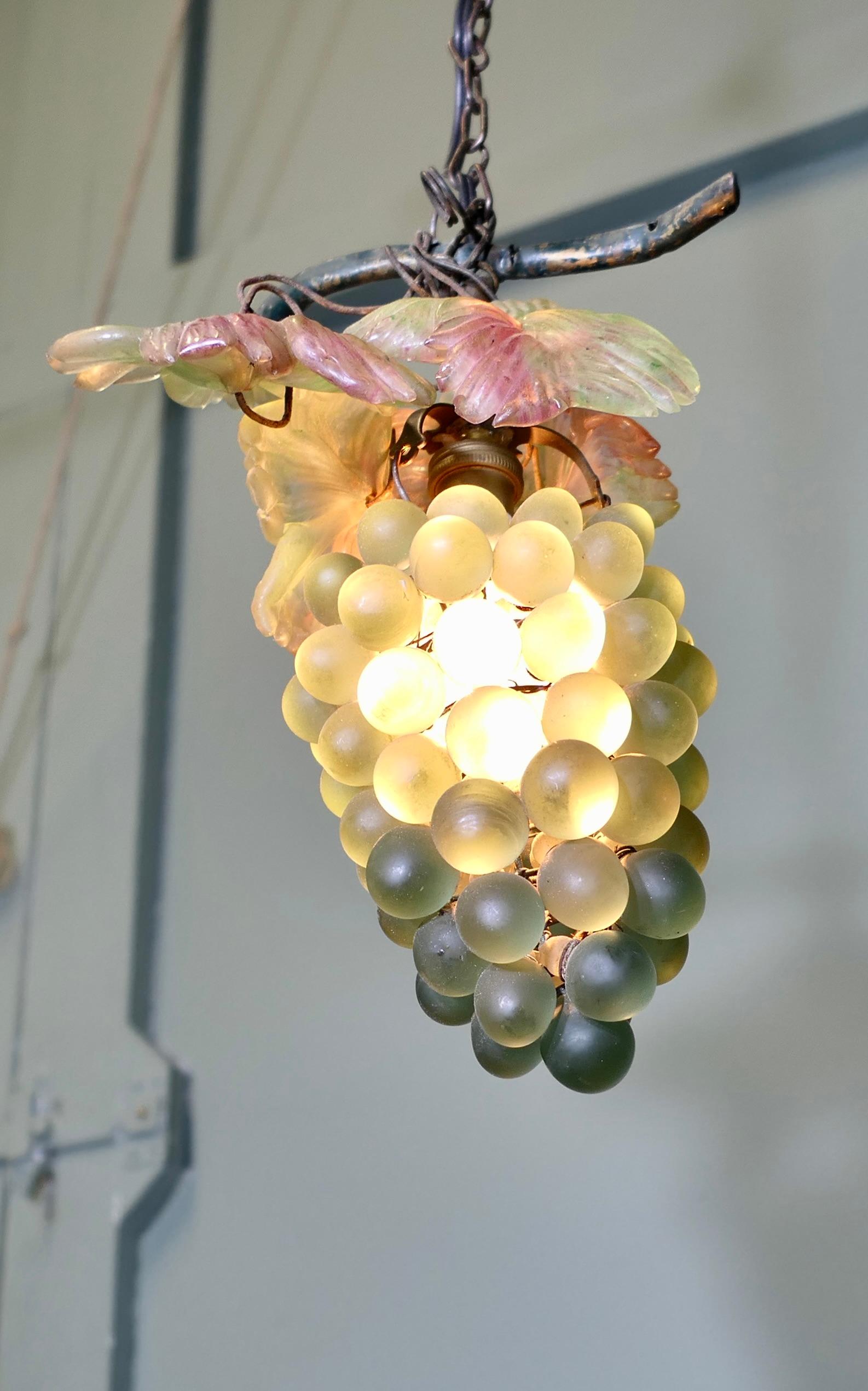 Araña de cristal de Murano de mediados de siglo 

Esta distintiva lámpara de araña de mediados de siglo tiene forma de racimo de uvas con maravillosos cristales verdes y rosas. Cableado a mano en un marco de metal con hojas de cristal verde y rosa