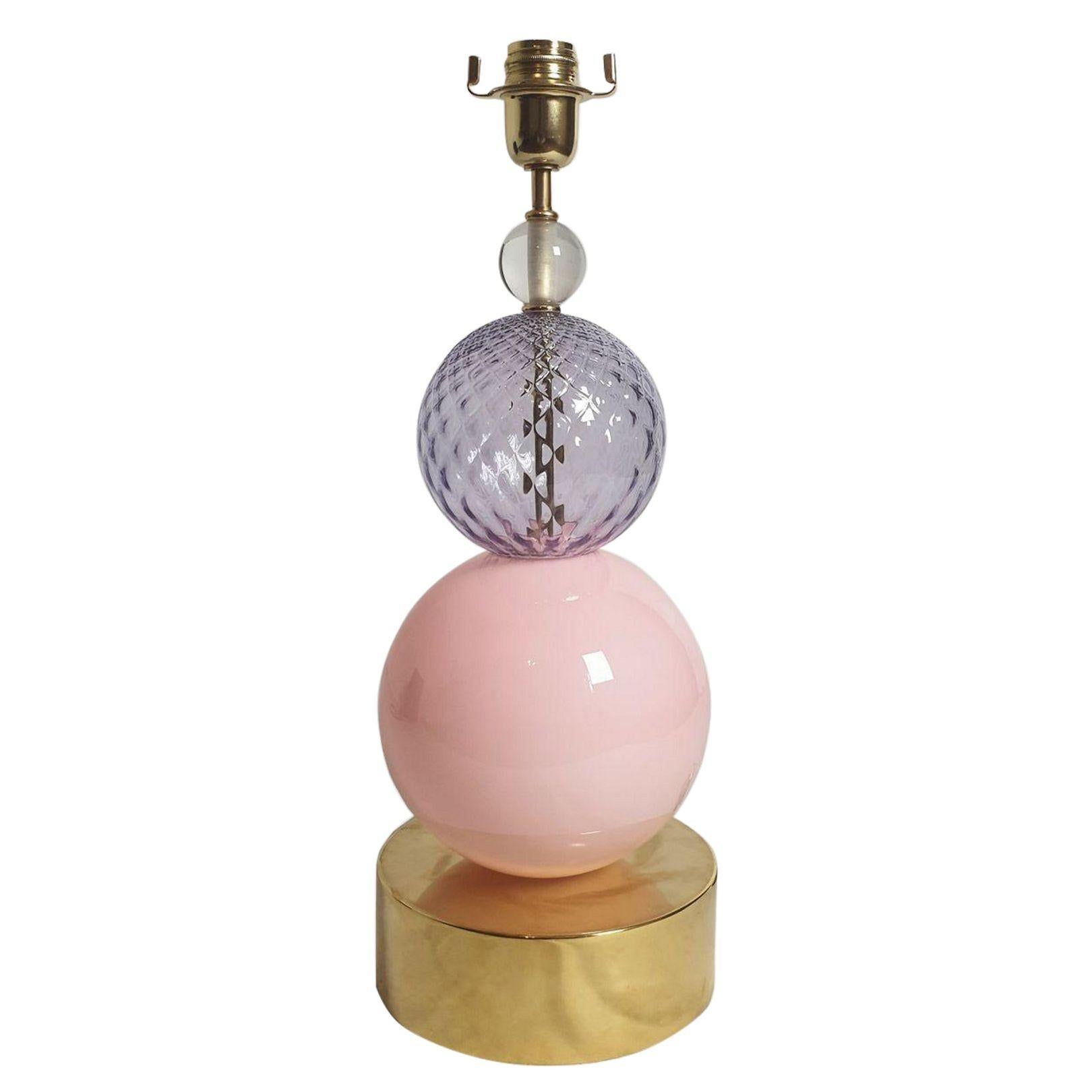 Lampada da tavolo in vetro di Murano del Mid Century Modern, Italia, stile Venini, anni '80.
La lampada da tavolo o da scrivania vintage è composta da una base cilindrica in ottone lucido, due grandi sfere in vetro di Murano rosa e lavanda
e una