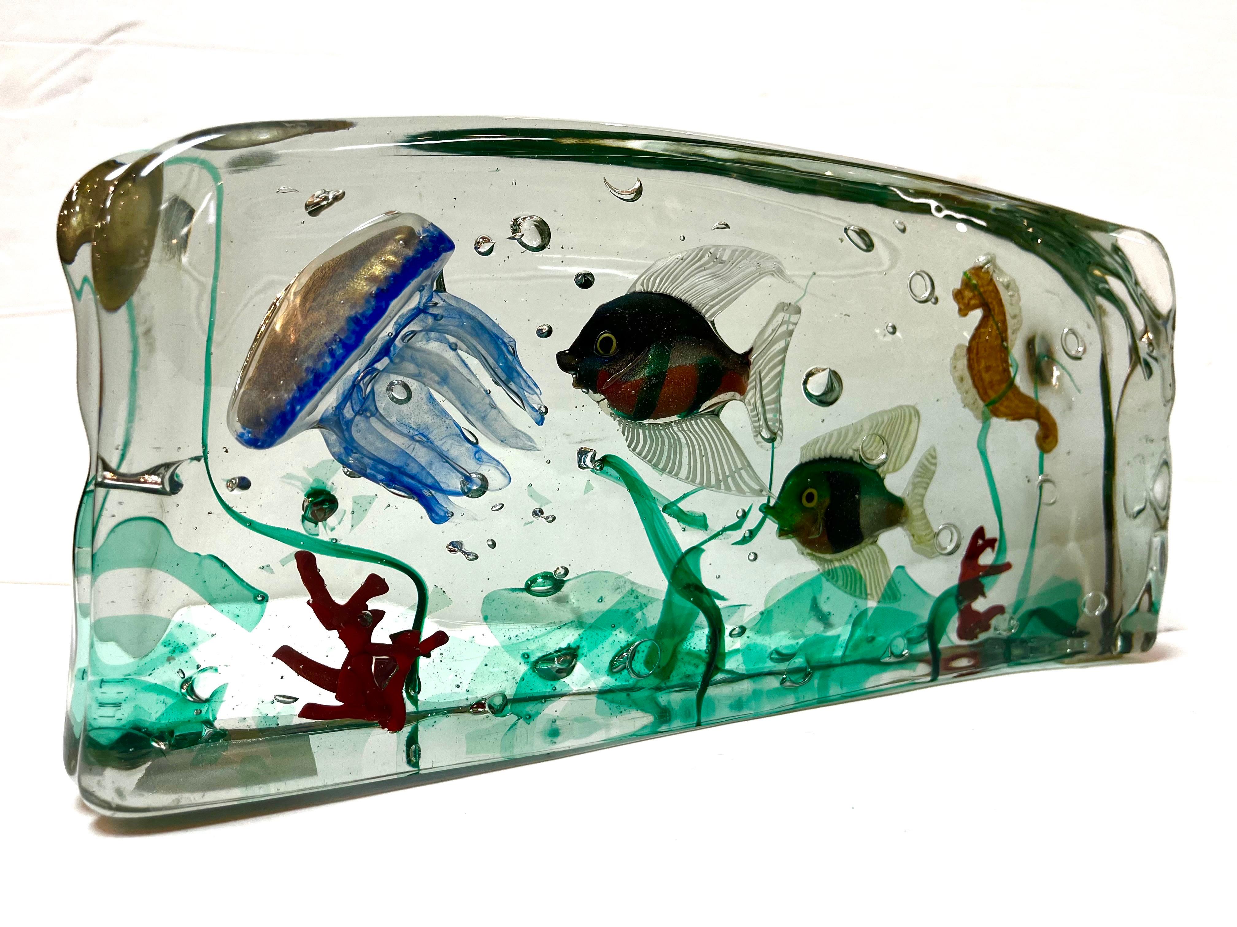 A mid century Murano glass aquarium sculpture in the style of those produced by Alfredo Barbini and Gino Cenedese. This sculpture features two fish, a jellyfish, a seahorse and various coral and seaweed. There are two felt squares attached to the