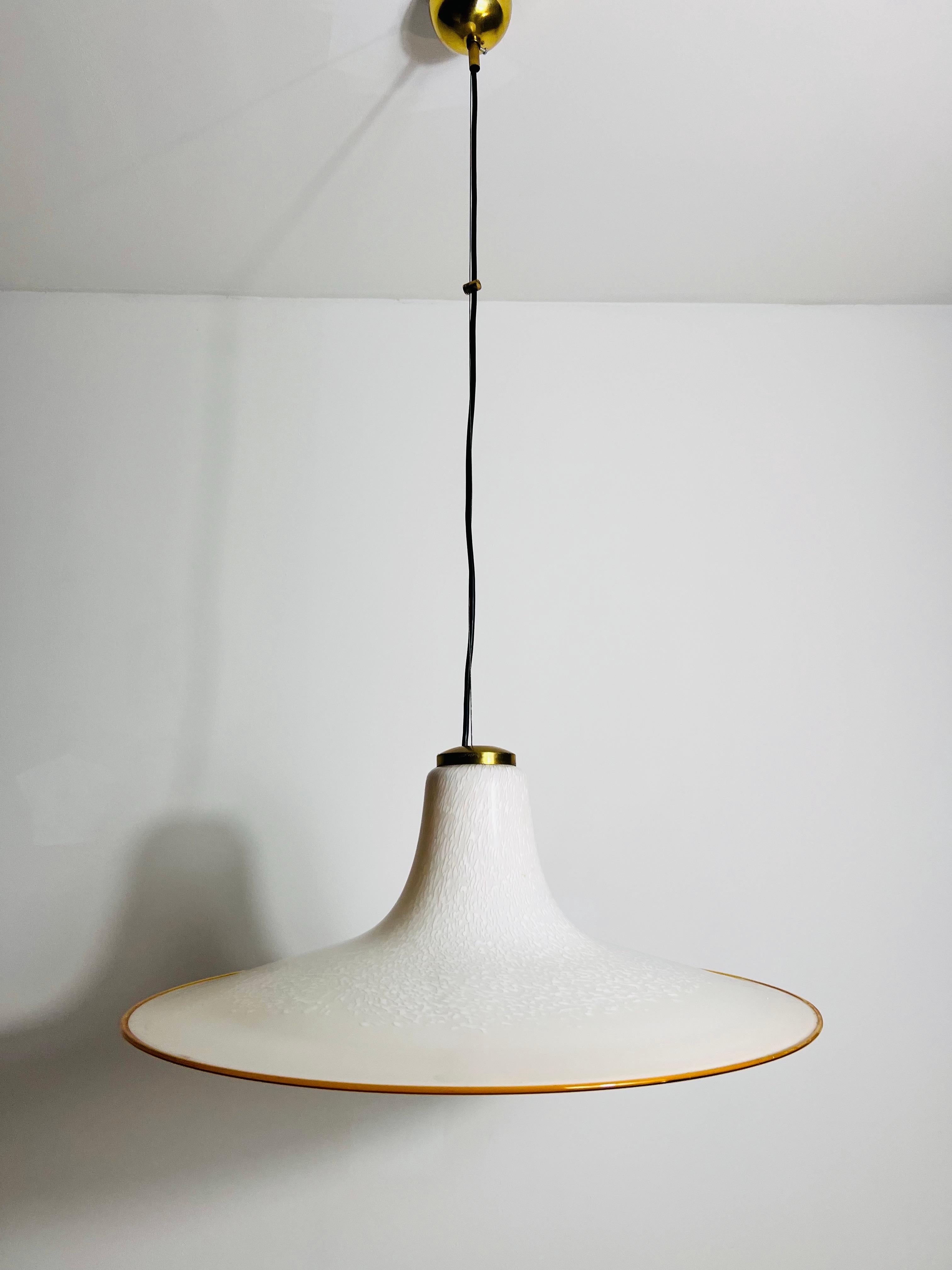 
Una splendida lampada da soffitto in vetro di Murano proveniente dall'Italia e risalente agli anni '60. Questo pezzo squisito è caratterizzato da un paralume unico a forma di cappello realizzato in vetro di Murano di alta qualità, che mostra