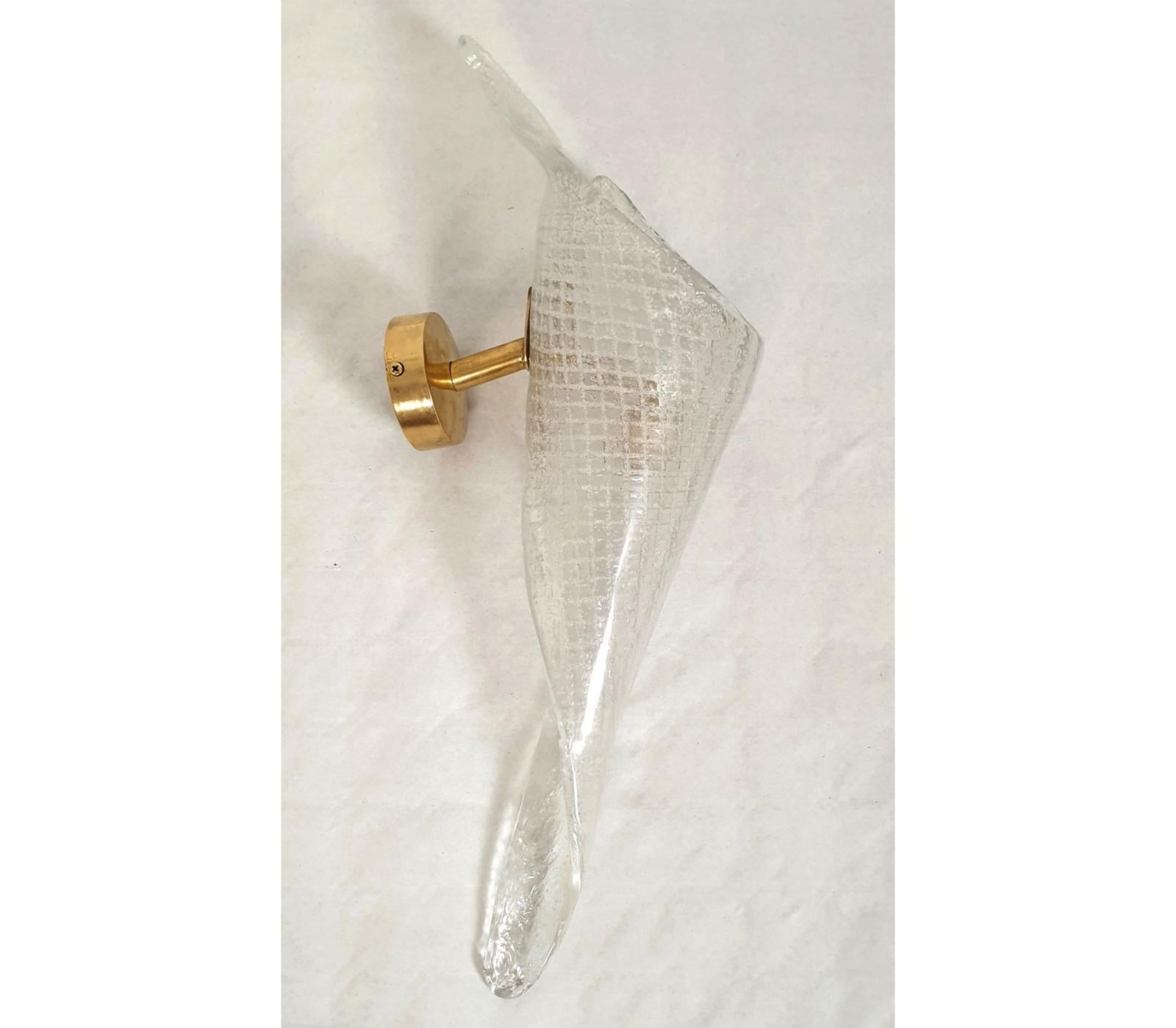 Pair of clear handmade Murano glass sconces, attributed to Seguso, Italy 1970s.
The Mid-Century sconces have brass mounts and a translucent twisted shape Murano glass shade.
The hand-blown and thick Murano glass has a grid pattern.
Each Murano