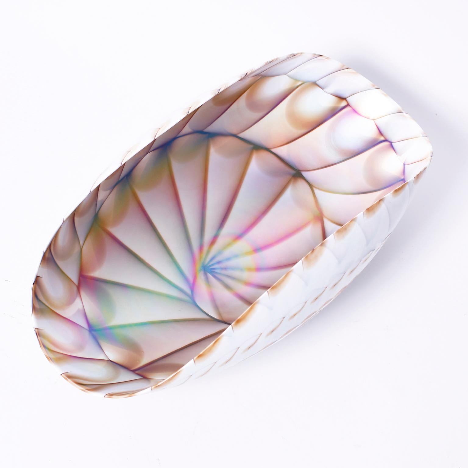 Sculpted hand blown glass bowl depicting a stylized sea shell with an iridescent example of the sacred geometry inside and sea inspired earth ties on the outside.