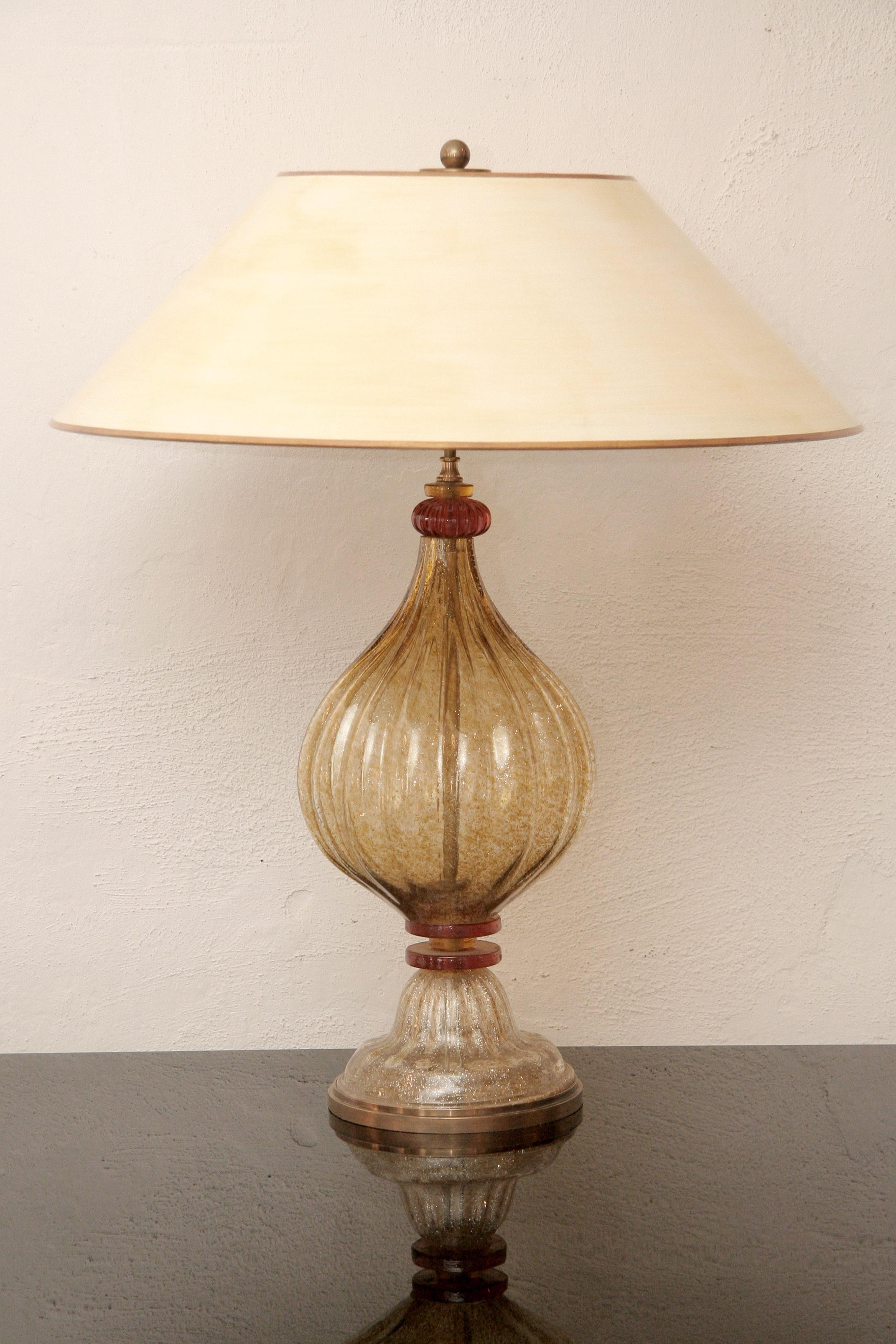 Italian Murano glass table lamp from the 1970s
Gold and orange glass - beige colored lamp shade
The middle shaft and foot is ribbed.
The foot stands in a patinated brass base, the lamp construction is also out of brass.
The large shade with a