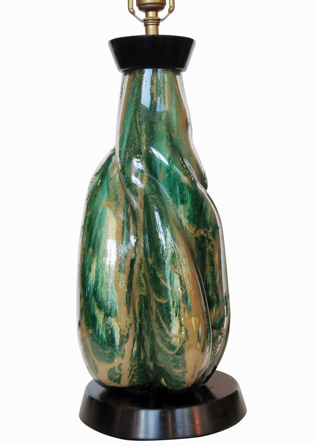 Large, elegant, hand blown green foil art Murano glass table lamp: Made in Italy, circa 1950, this large, free-formed, hand blown centerpiece is fixed to a decorative laquered wood base with brass accents along the top. The piece is in the style and