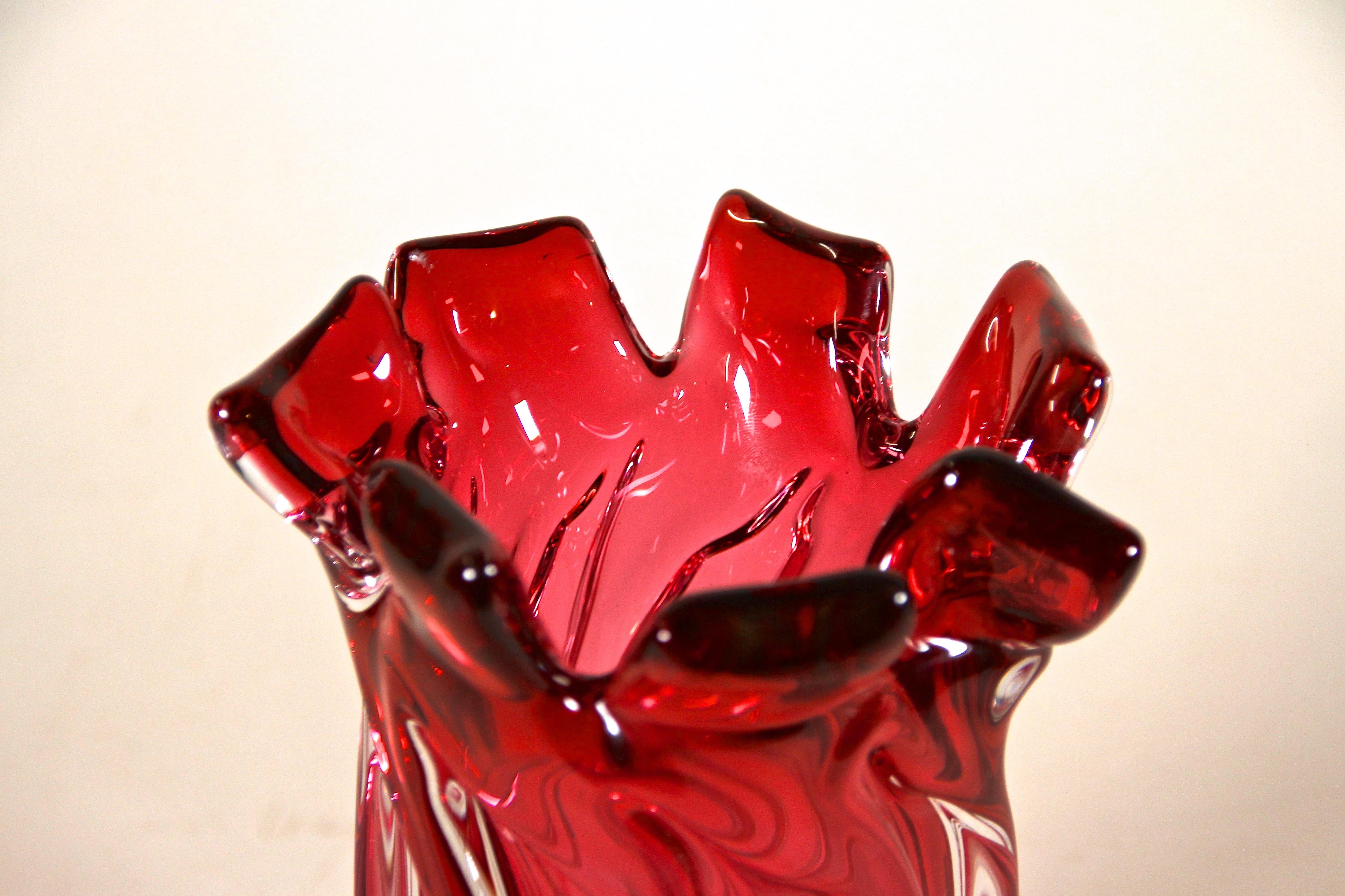 Delicate mid century Murano glass vase from the renown glass art workshops in Italy. Artfully made in the period around 1960 this fantastic shaped glass vase shows a lovely coloration in a beautiful pink red tone. The twisted body looks gorgeous and