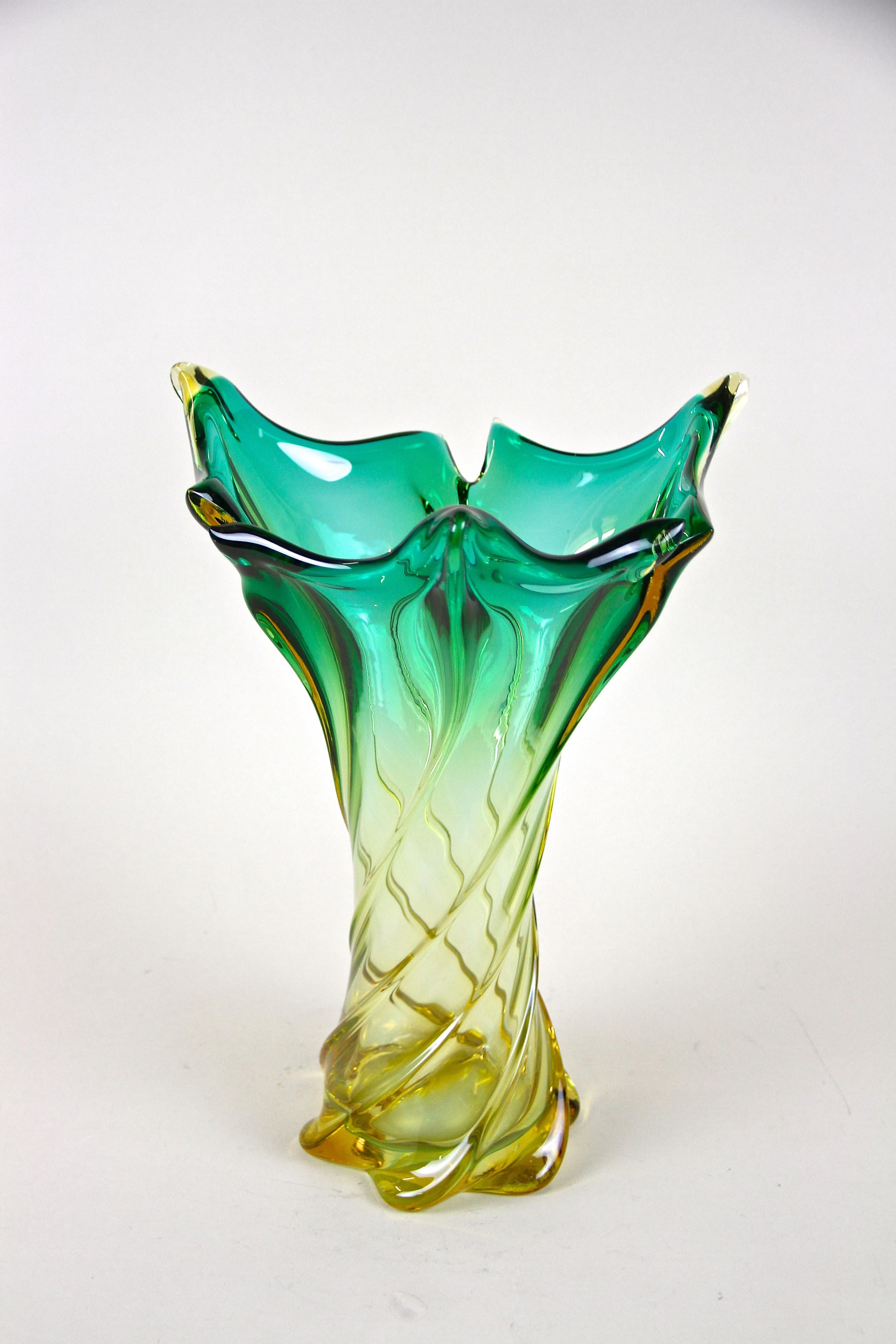 Beautifully shaped, large mid-century Murano glass vase from the renown workshops in Italy around 1960. An exceptional item with twisted body combined with fantastic coloration. From shining green tones over yellow down to a beautiful amber colored