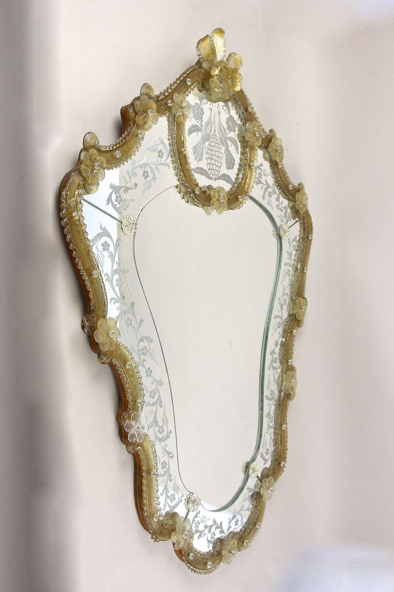 Stunning, one of a kind large mid century Murano glass wall mirror from the famous workshops of the little island in Venice/ Italy around 1950. This absolute extraordinary example of a murano glass mirror impresses with its phenomenal looking shape