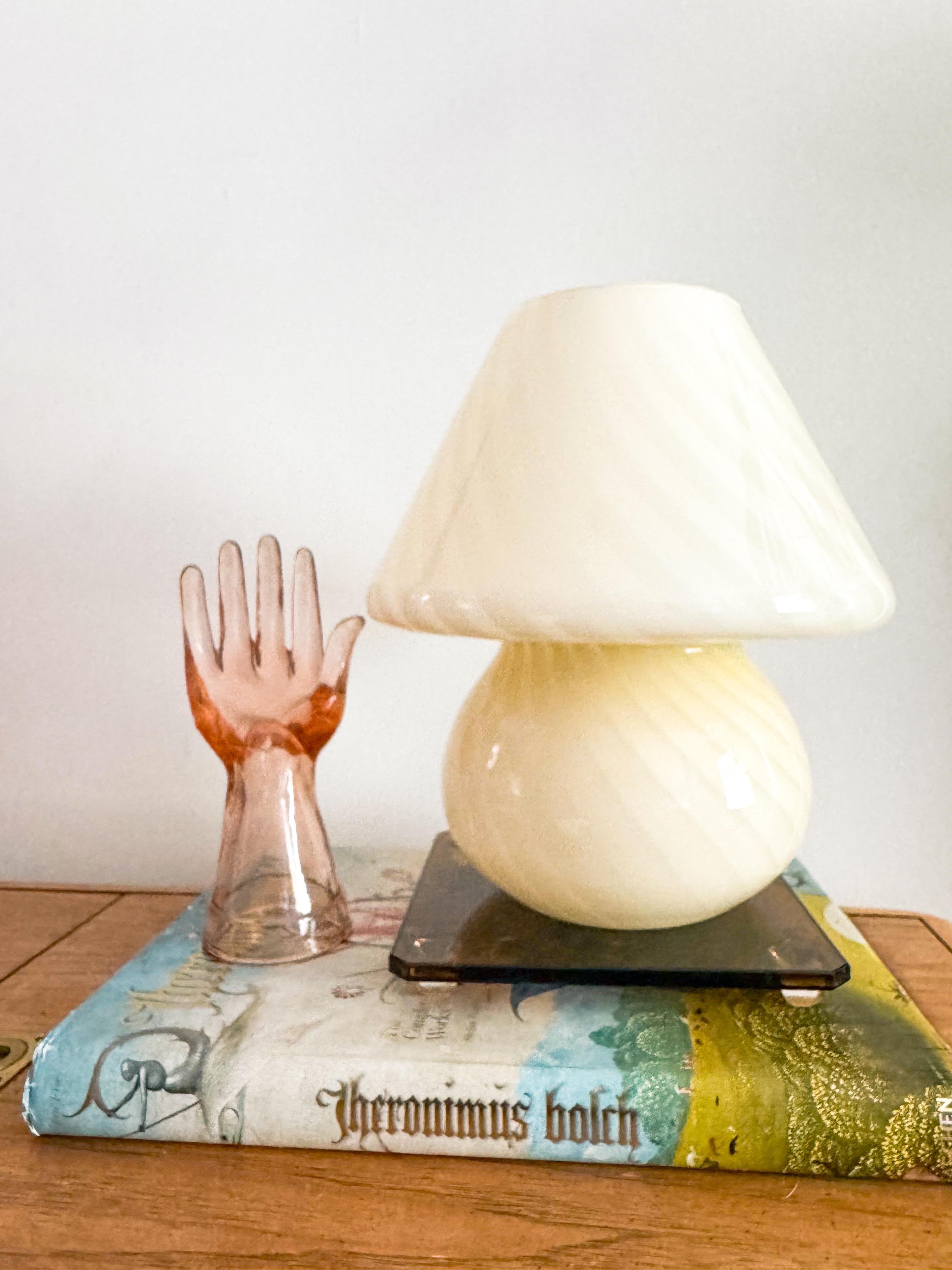 Eine atemberaubende Pilzlampe aus Murano-Glas in einem zarten, hellgelben Butterton, die in der charakteristischen Wirbeltechnik hergestellt wurde. Der zarte Farbverlauf verleiht dem Glas eine ombréartige Tiefe, die bei Beleuchtung einen warmen,